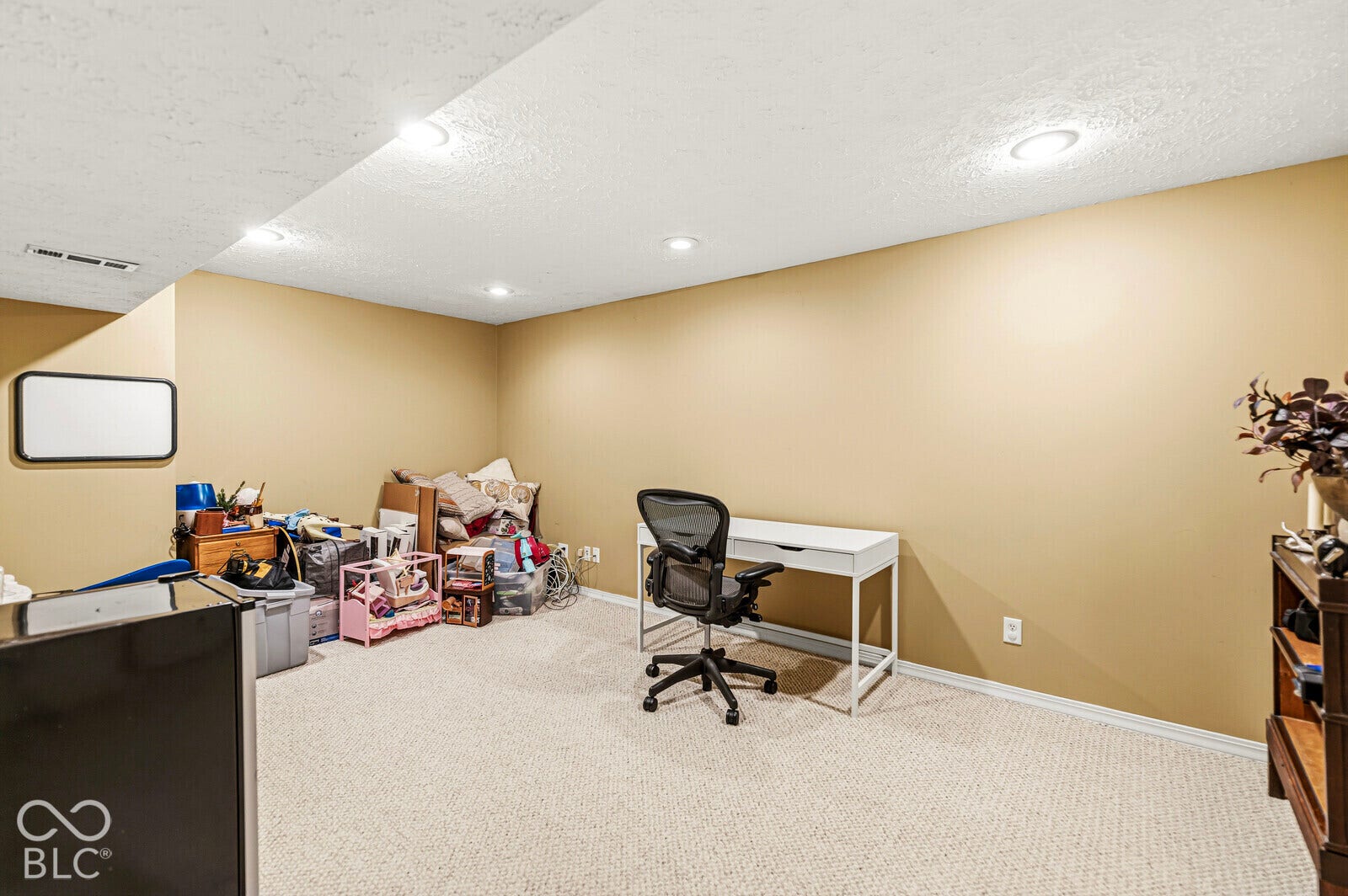 Recessed lighting, light-colored carpet, and neutral wall tones