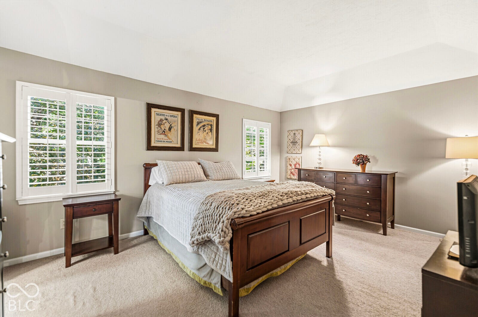 Vaulted ceiling, neutral wall tones, plantation shutters, and soft carpeting create an inviting space