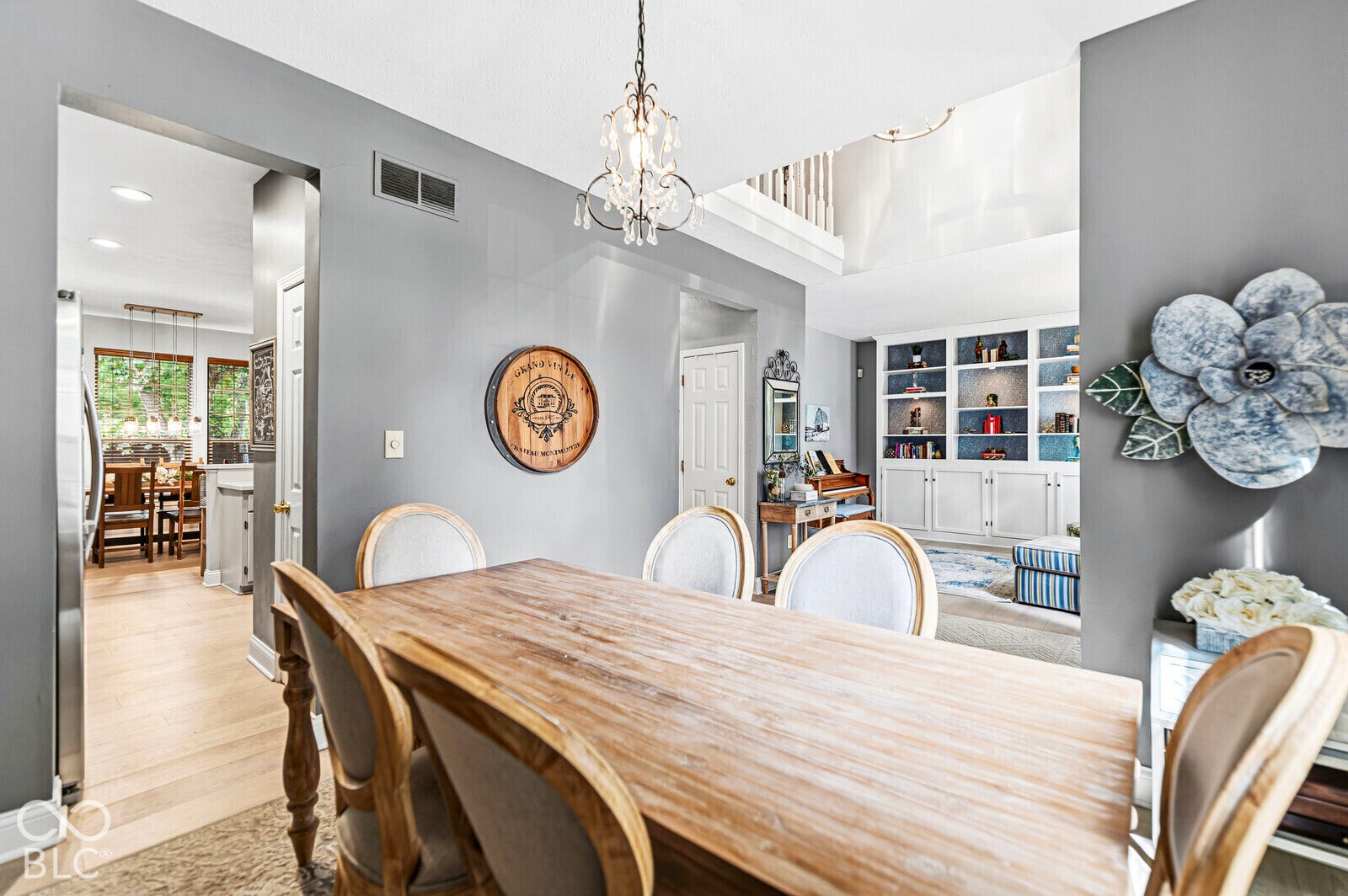 Dining space featuring wood-finish flooring, a chandelier, and a built-in shelving unit