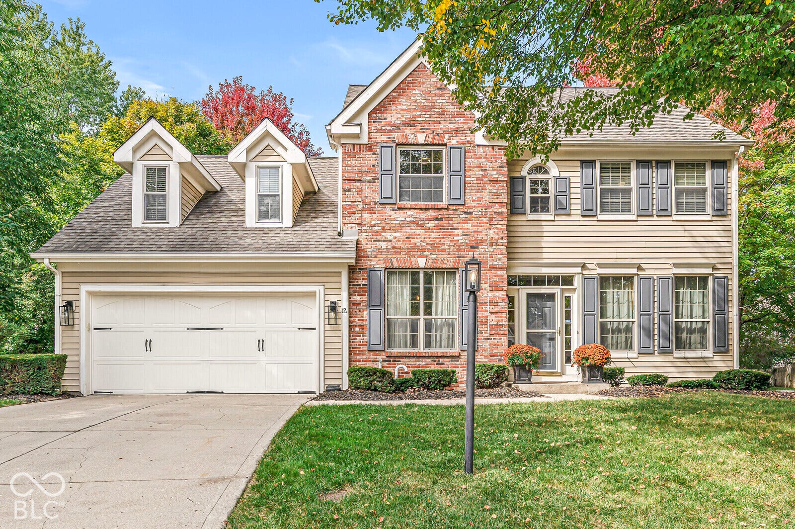 Brick and siding exterior with attached two-car garage and a concrete driveway