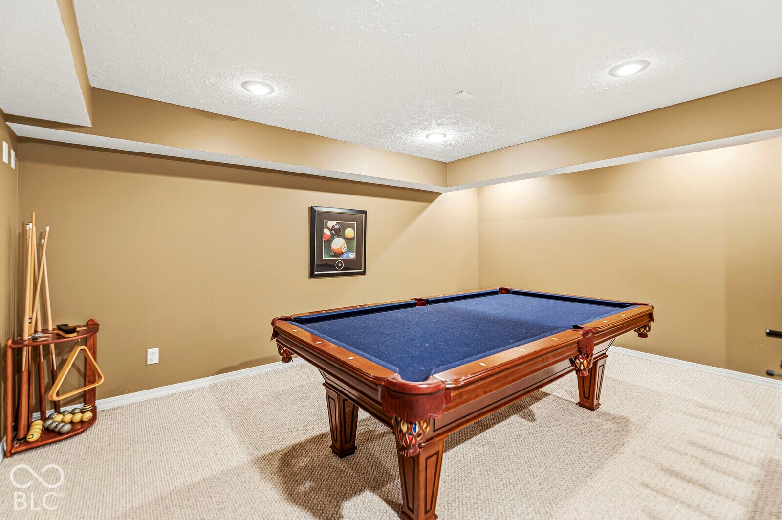 Recessed lighting illuminates this carpeted room with neutral-toned walls