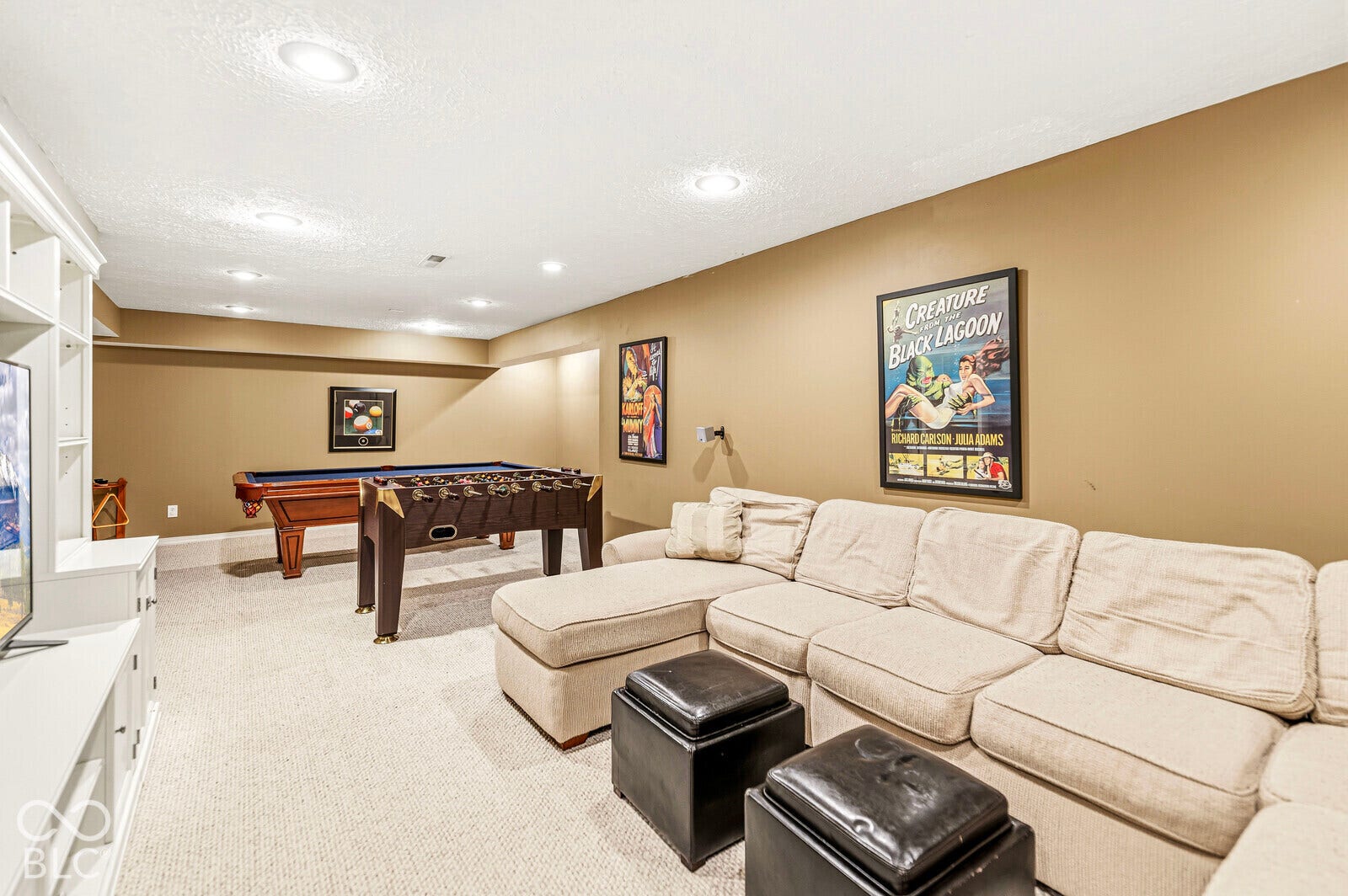 Recessed lighting illuminates this room featuring carpet flooring and ample wall space