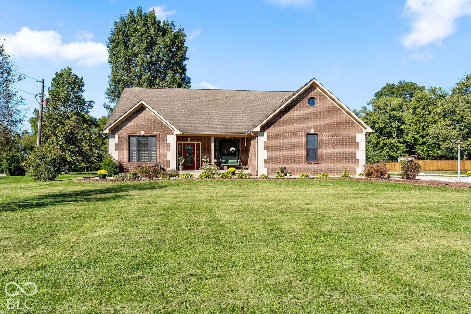 Brick exterior with contrasting white corner accents, covered front entry porch, and an oval window accent