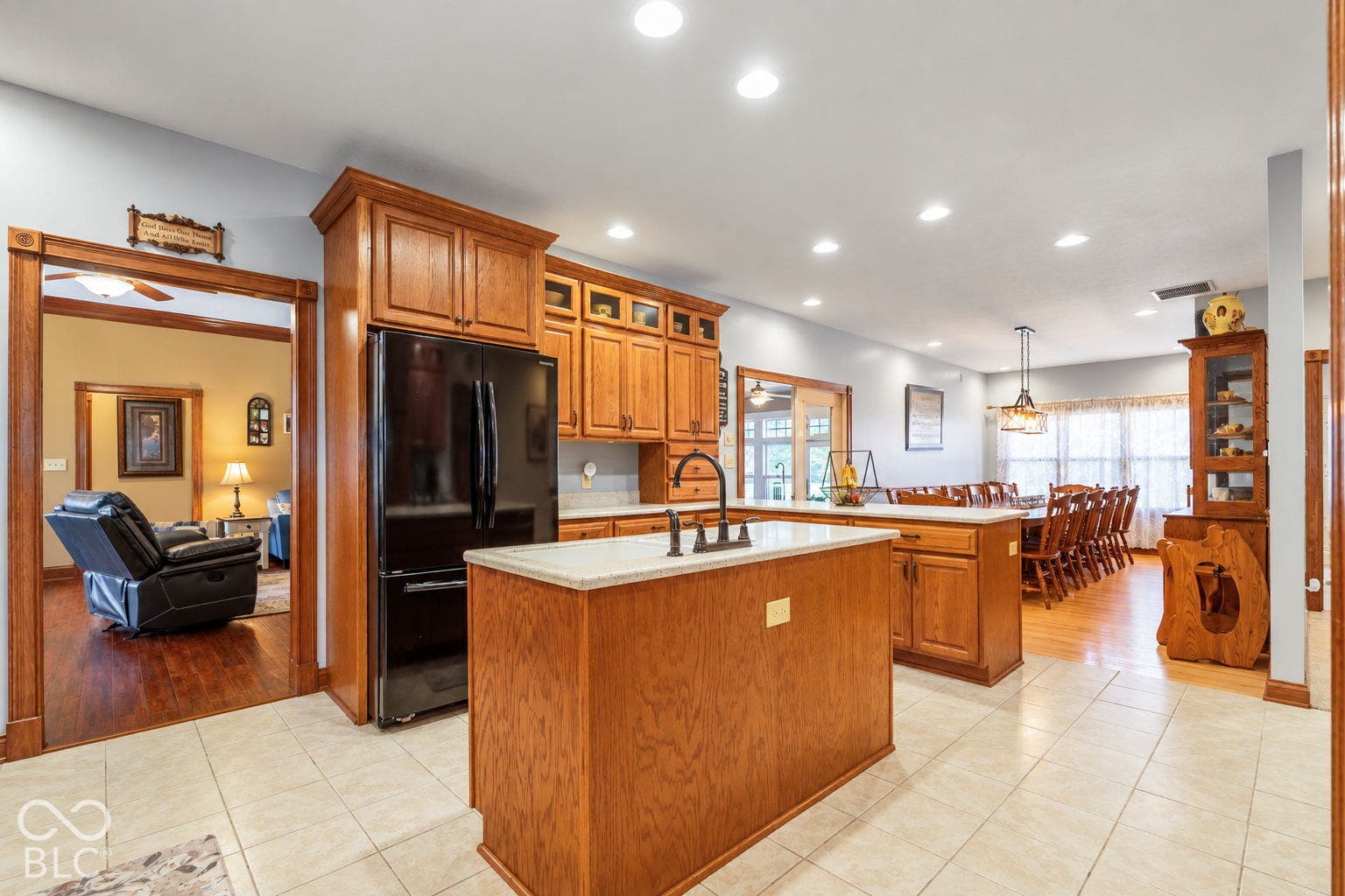 Kitchen featuring wood cabinetry, a center island with countertop, and black appliances