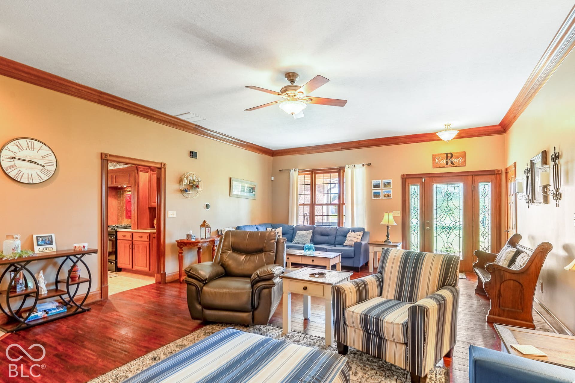 Wood-finish flooring throughout, featuring a large ceiling fan with integrated lighting