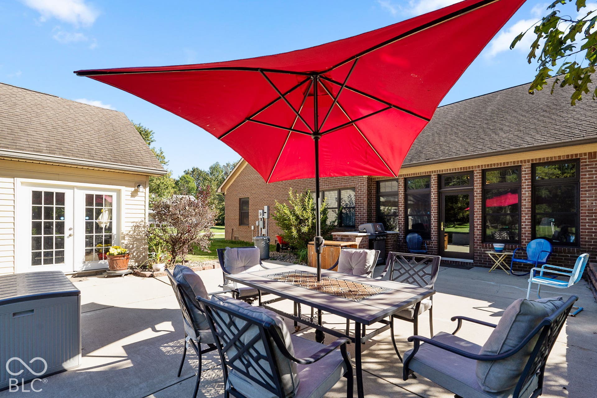 Expansive concrete patio with direct access to interior spaces and a separate exterior structure