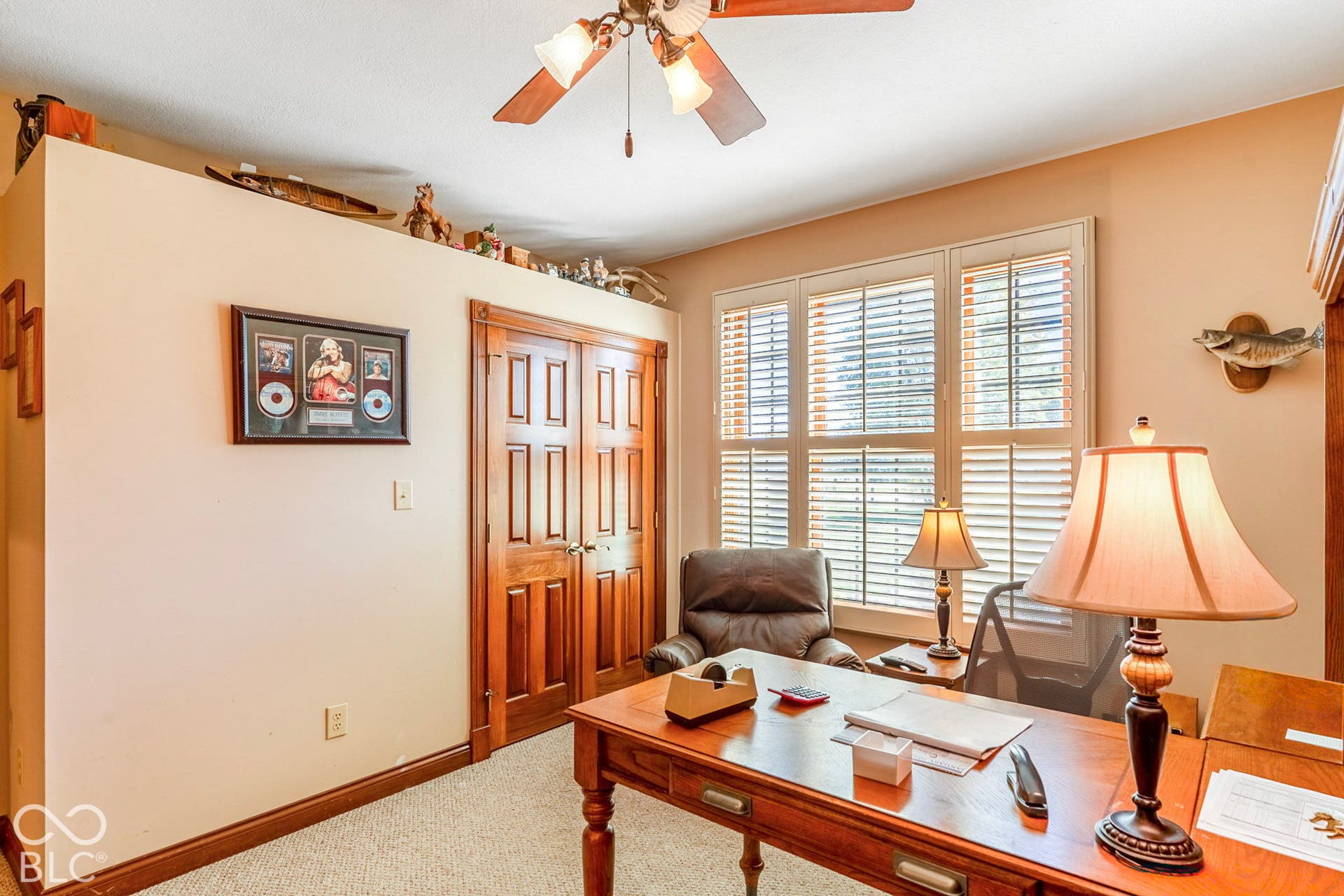 Carpeted flooring, wood-finish double doors, and window with wood-finish blinds