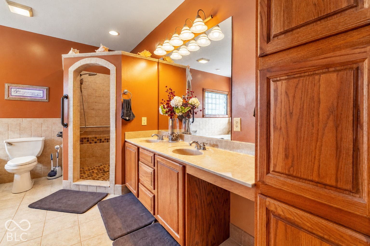 Dual sink vanity with wood cabinetry and light-toned countertop