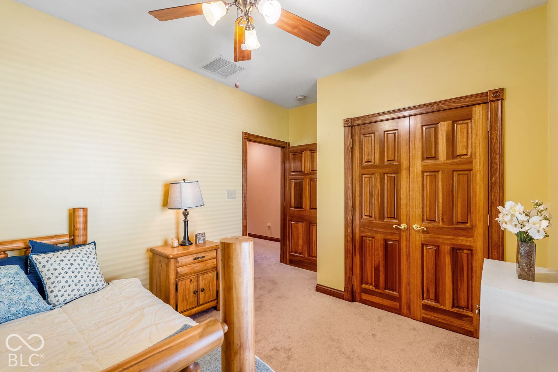 Ceiling fan with integrated lighting, wood panel interior doors, wood-finish trim, and carpet flooring