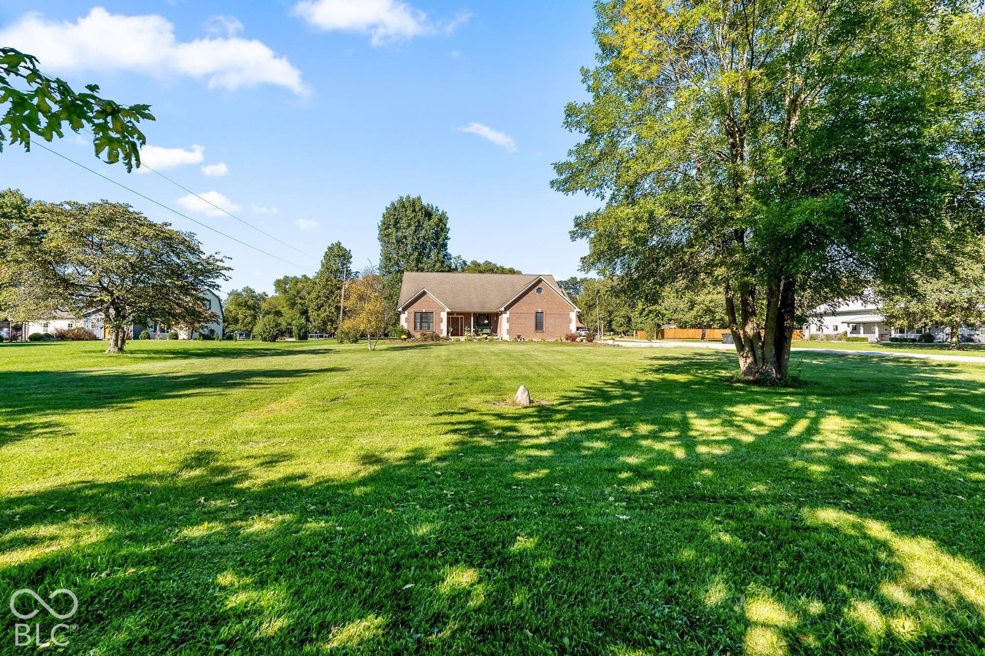Spacious front lawn with mature trees