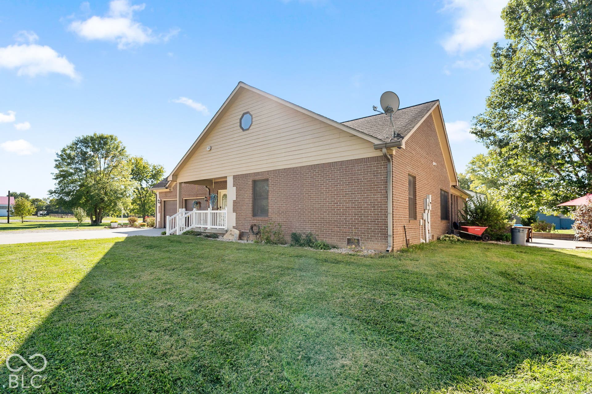 Brick exterior with a covered porch, detached garage, and a circular window accent