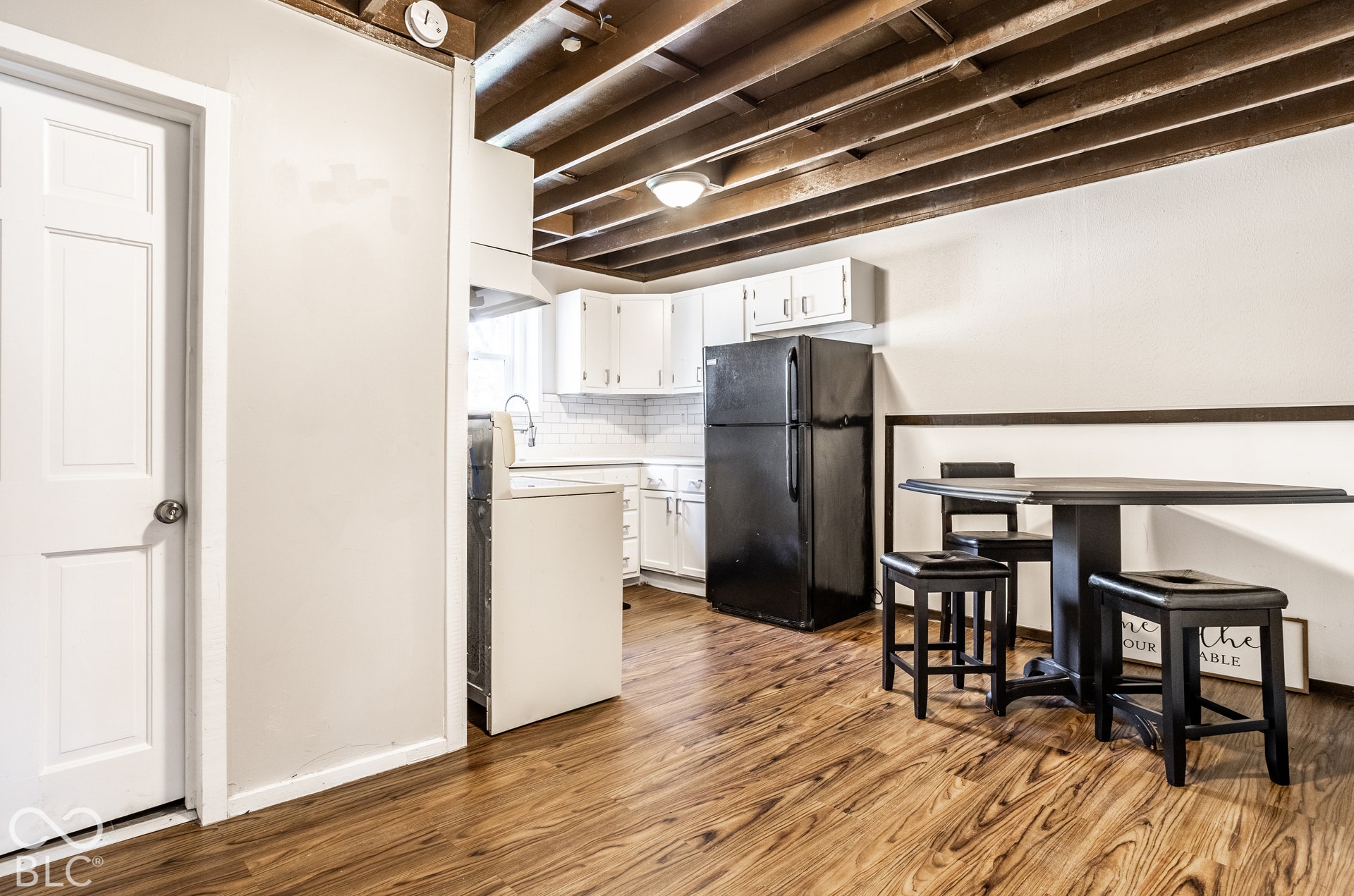 Open-concept kitchen with white cabinetry and a subway tile backsplash