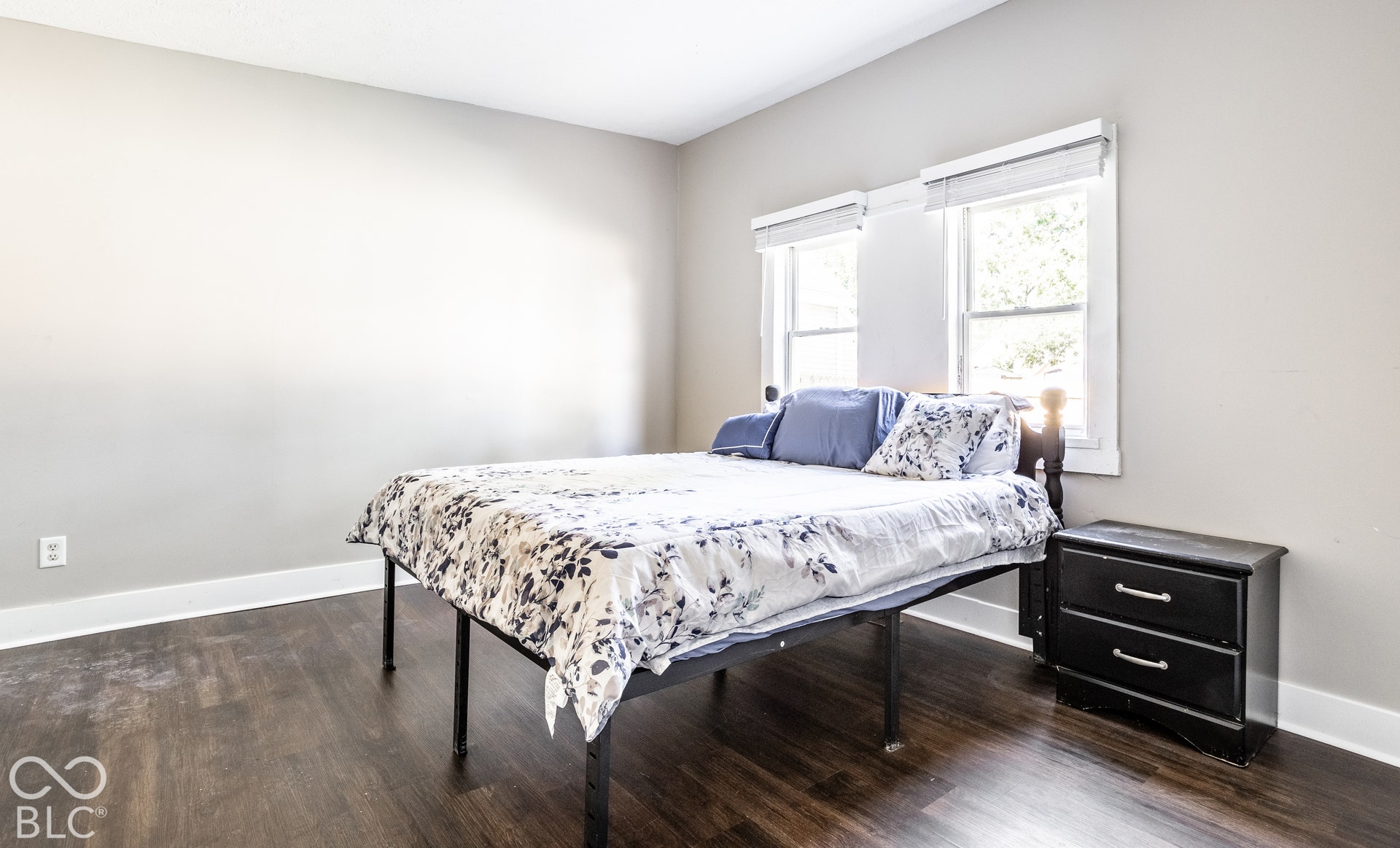 Light gray walls, dark wood-finish flooring, white window trim, and white baseboards
