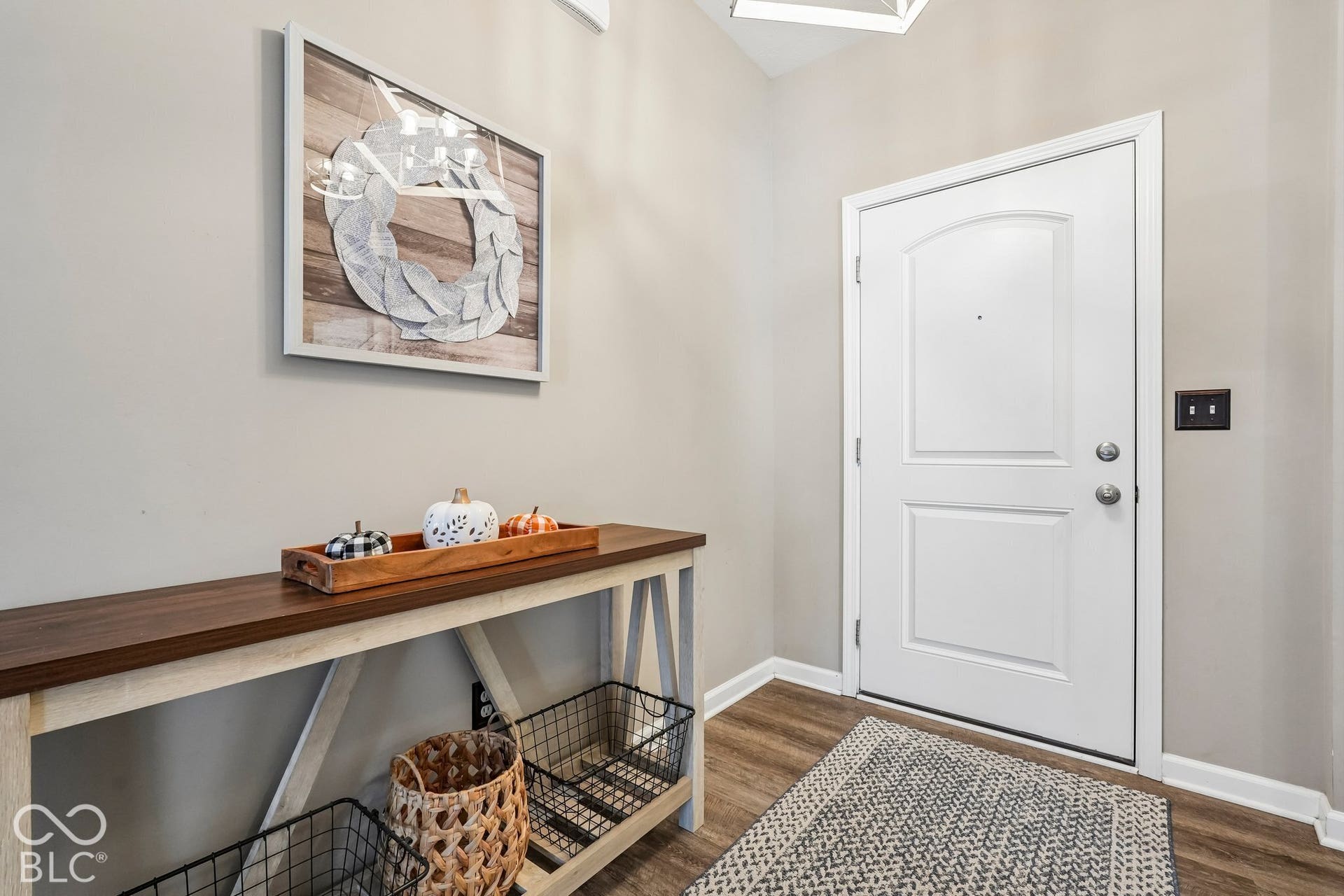 2945 W Calimanco Lane, Monrovia, IN 46157 White paneled entry door with an arched top panel, wood-finish flooring, light-toned wall paint, and a built-in overhead light fixture