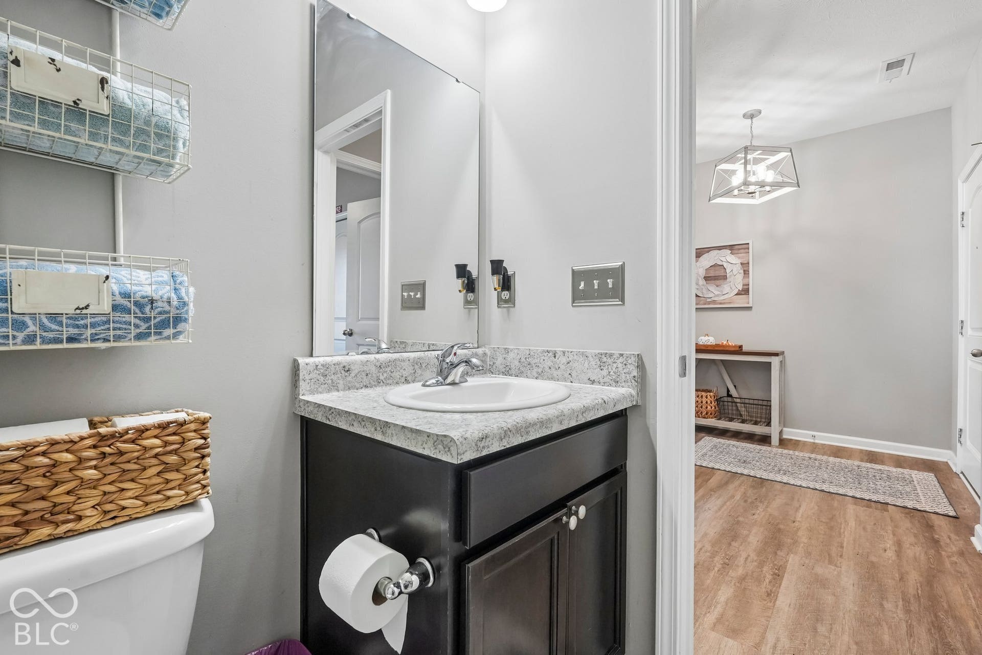 2945 W Calimanco Lane, Monrovia, IN 46157 Vanity with a white basin and speckled countertop, dark wood-finish cabinetry, and a large wall-mounted mirror