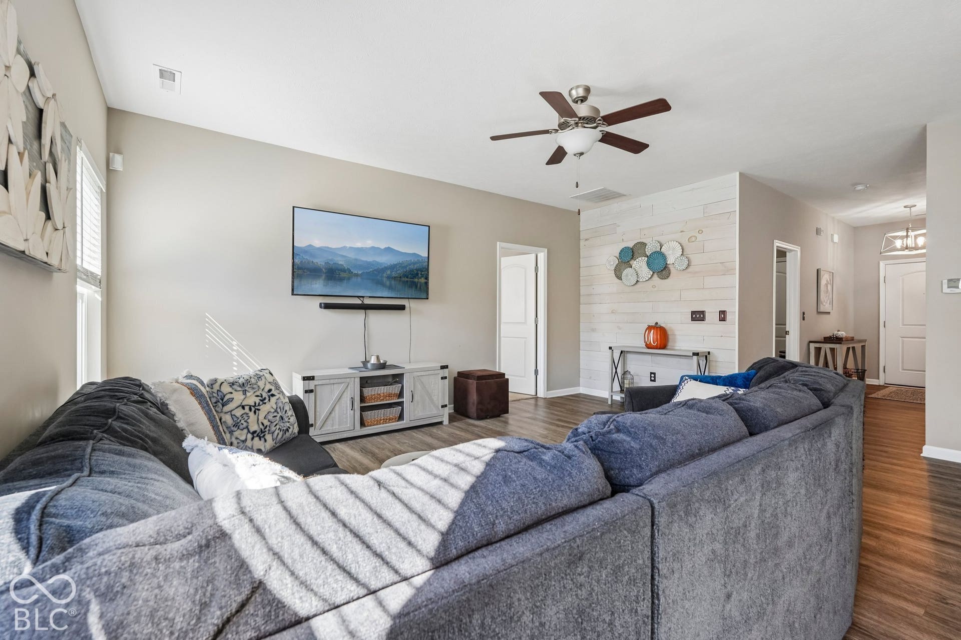 2945 W Calimanco Lane, Monrovia, IN 46157 Spacious living area featuring wood-finish flooring, a ceiling fan, and a shiplap accent wall
