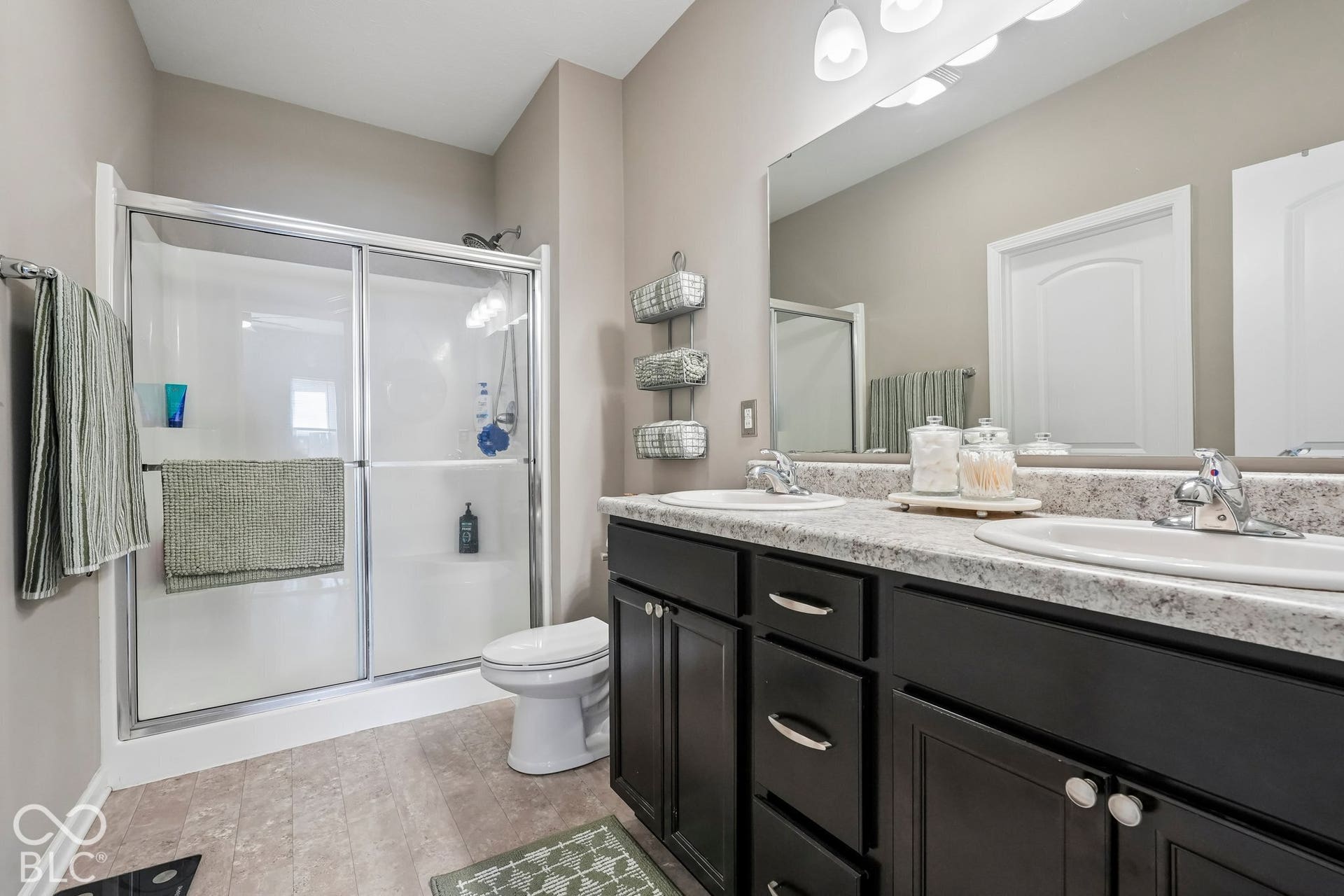 2945 W Calimanco Lane, Monrovia, IN 46157 Double vanity with undermount sinks, spacious mirror, dark wood-finish cabinetry, and a shower with sliding glass doors