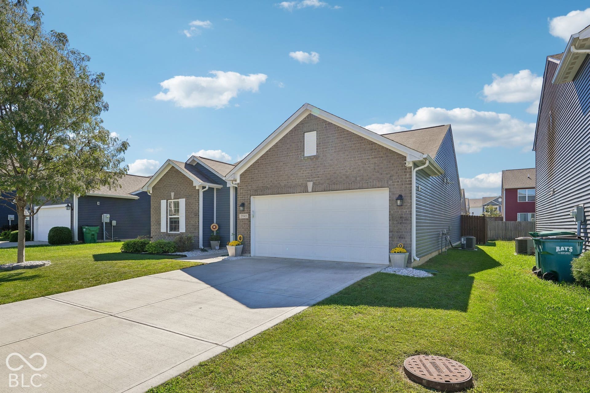 2945 W Calimanco Lane, Monrovia, IN 46157 Brick and siding exterior with an attached garage, concrete driveway, and mature landscaping