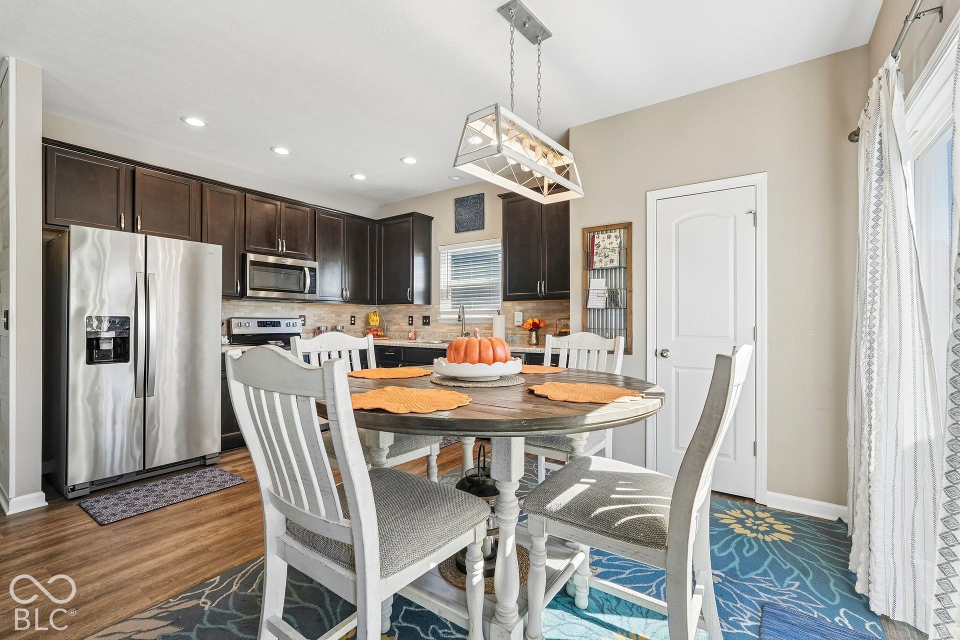 2945 W Calimanco Lane, Monrovia, IN 46157 Dark wood-finish cabinetry, stainless steel appliances, wood-finish flooring, recessed lighting, and a contemporary linear pendant light