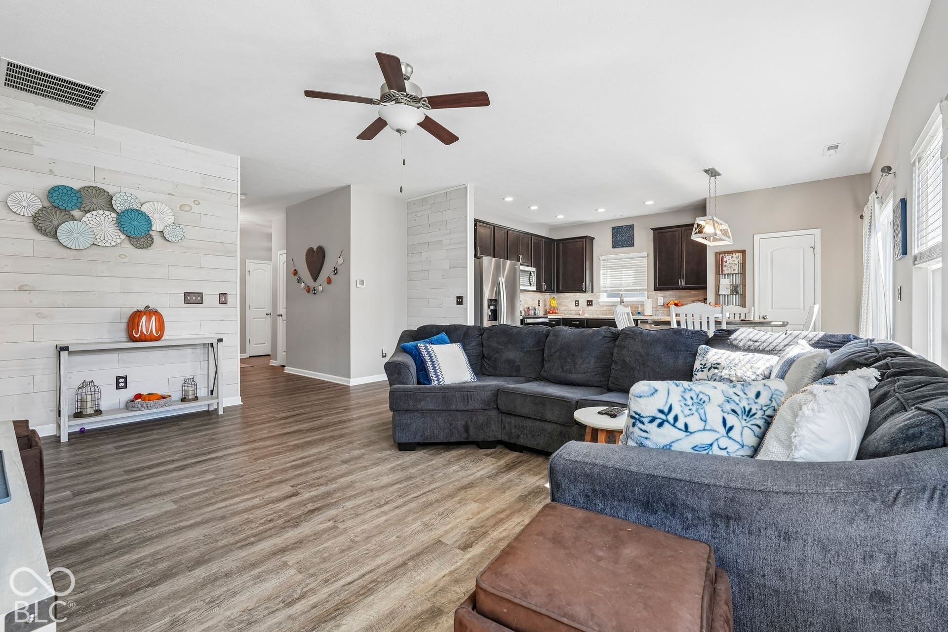 2945 W Calimanco Lane, Monrovia, IN 46157 Open-concept living area featuring wood-finish flooring, a ceiling fan with integrated lighting, and a white shiplap accent wall