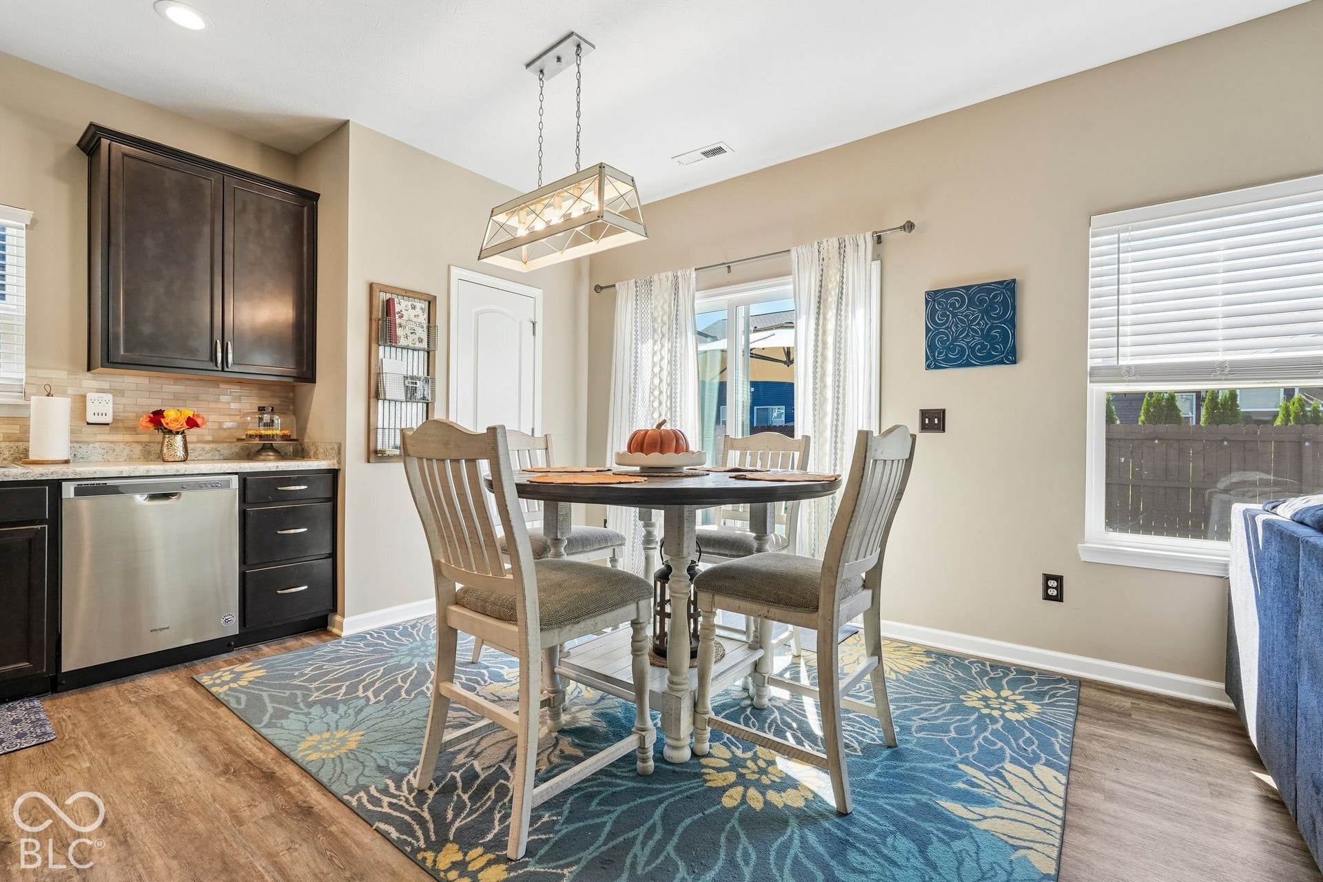 2945 W Calimanco Lane, Monrovia, IN 46157 Dark wood-finish cabinetry, stainless steel dishwasher, light-toned backsplash tiling, wood-finish flooring, and a sliding glass door