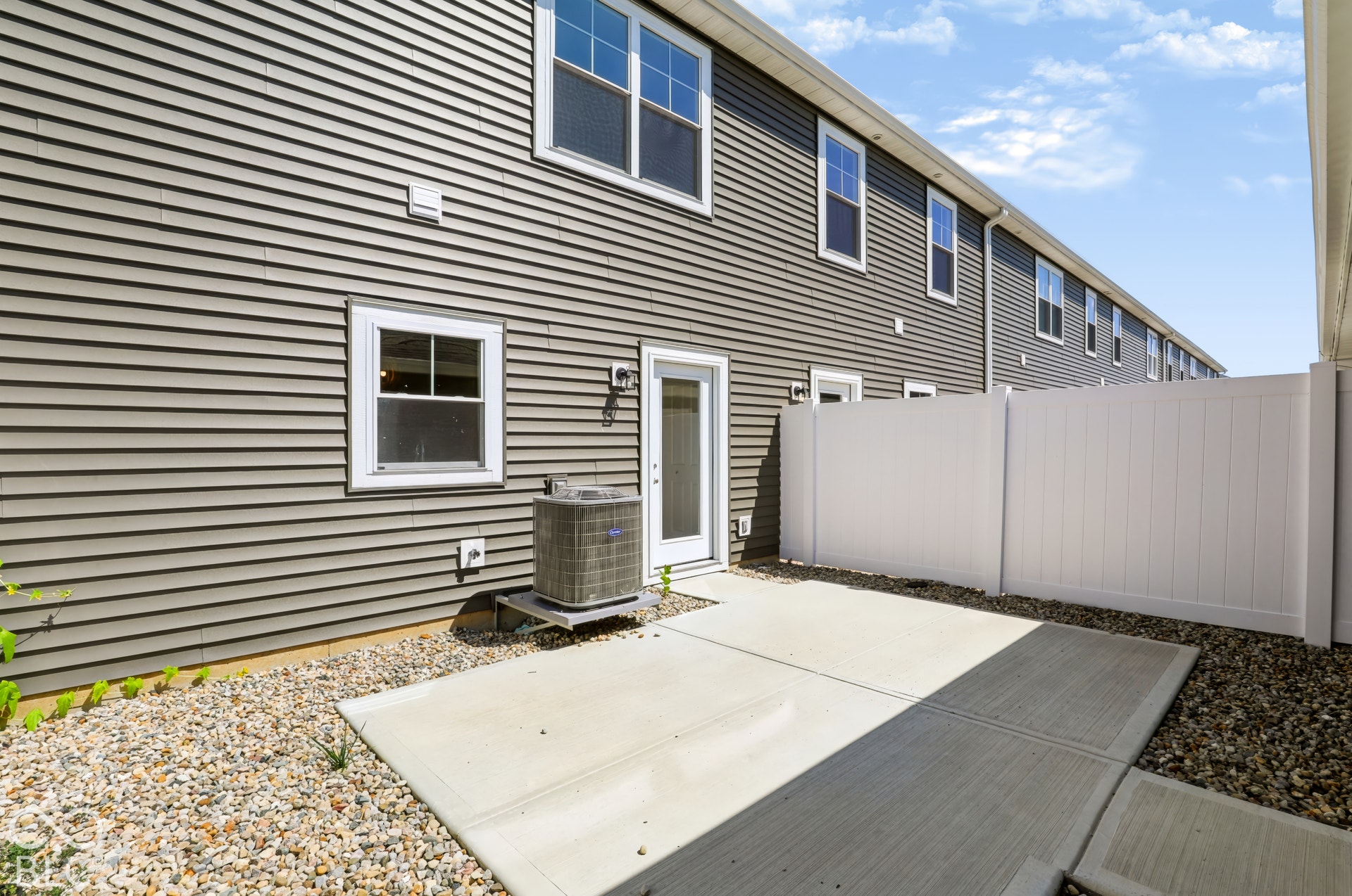 Private patio area with concrete slab and gravel landscaping