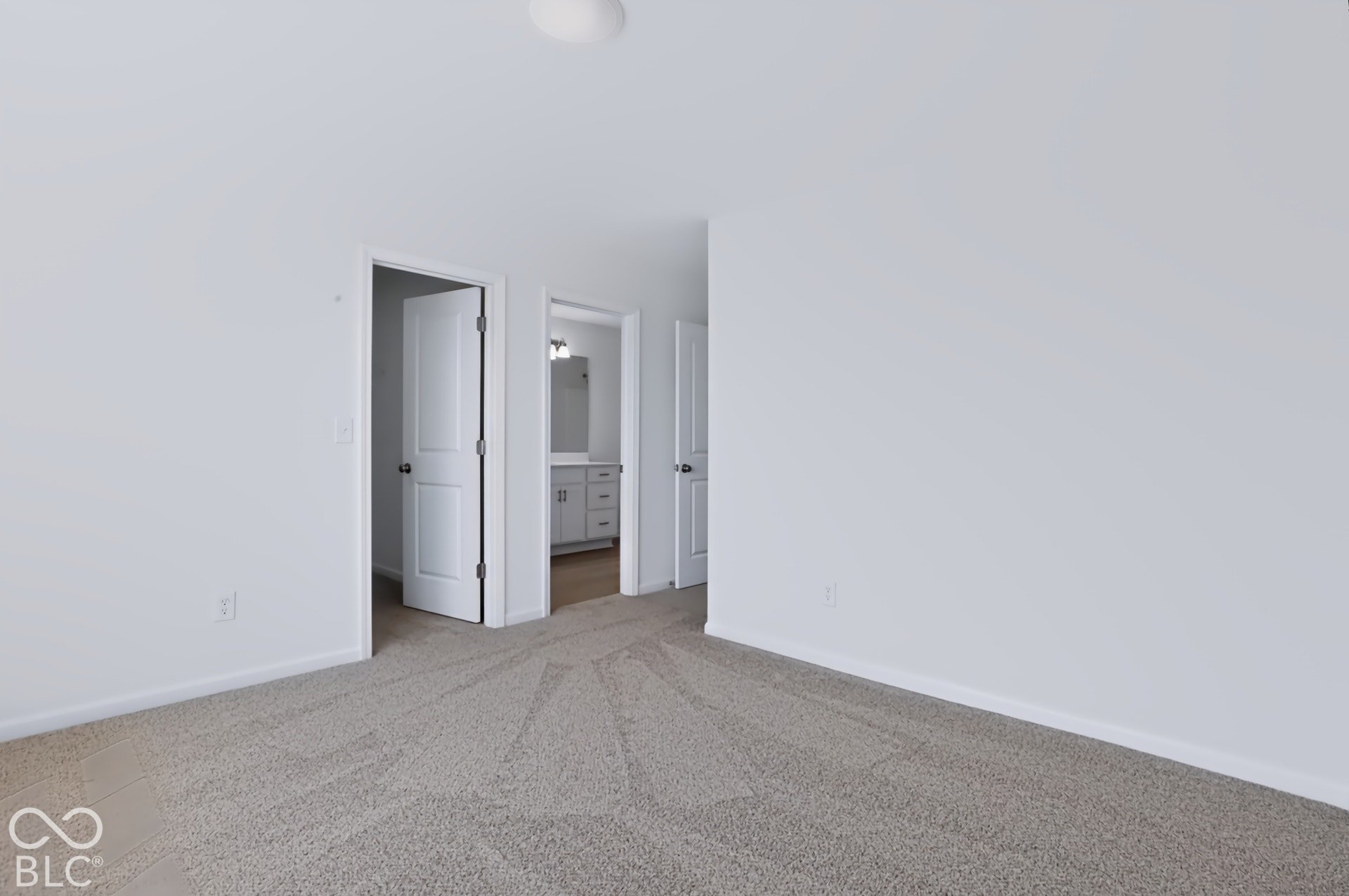 Neutral-toned carpeting, white walls, and a ceiling-mounted light fixture