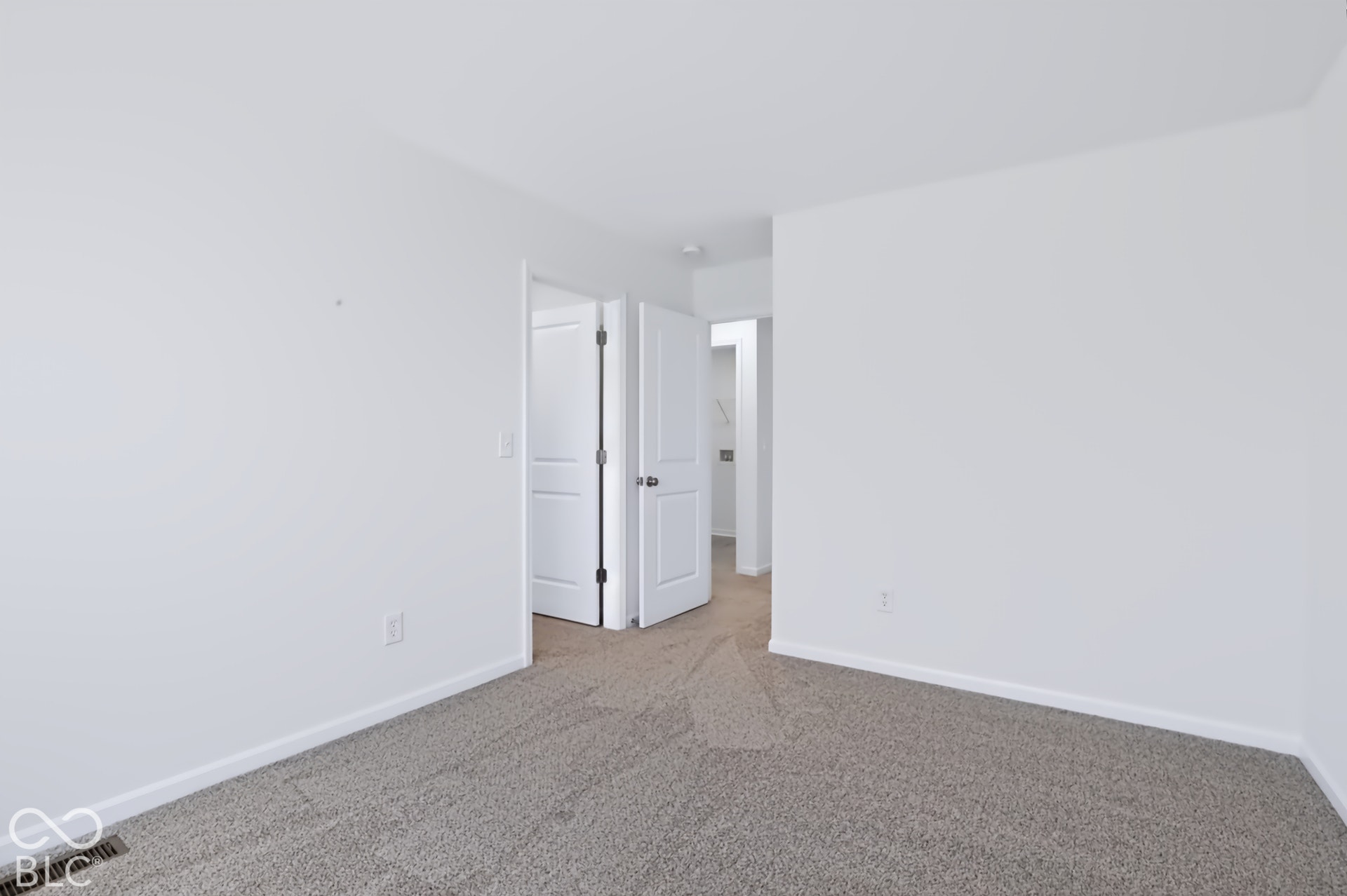 Carpeted flooring with white wall paint