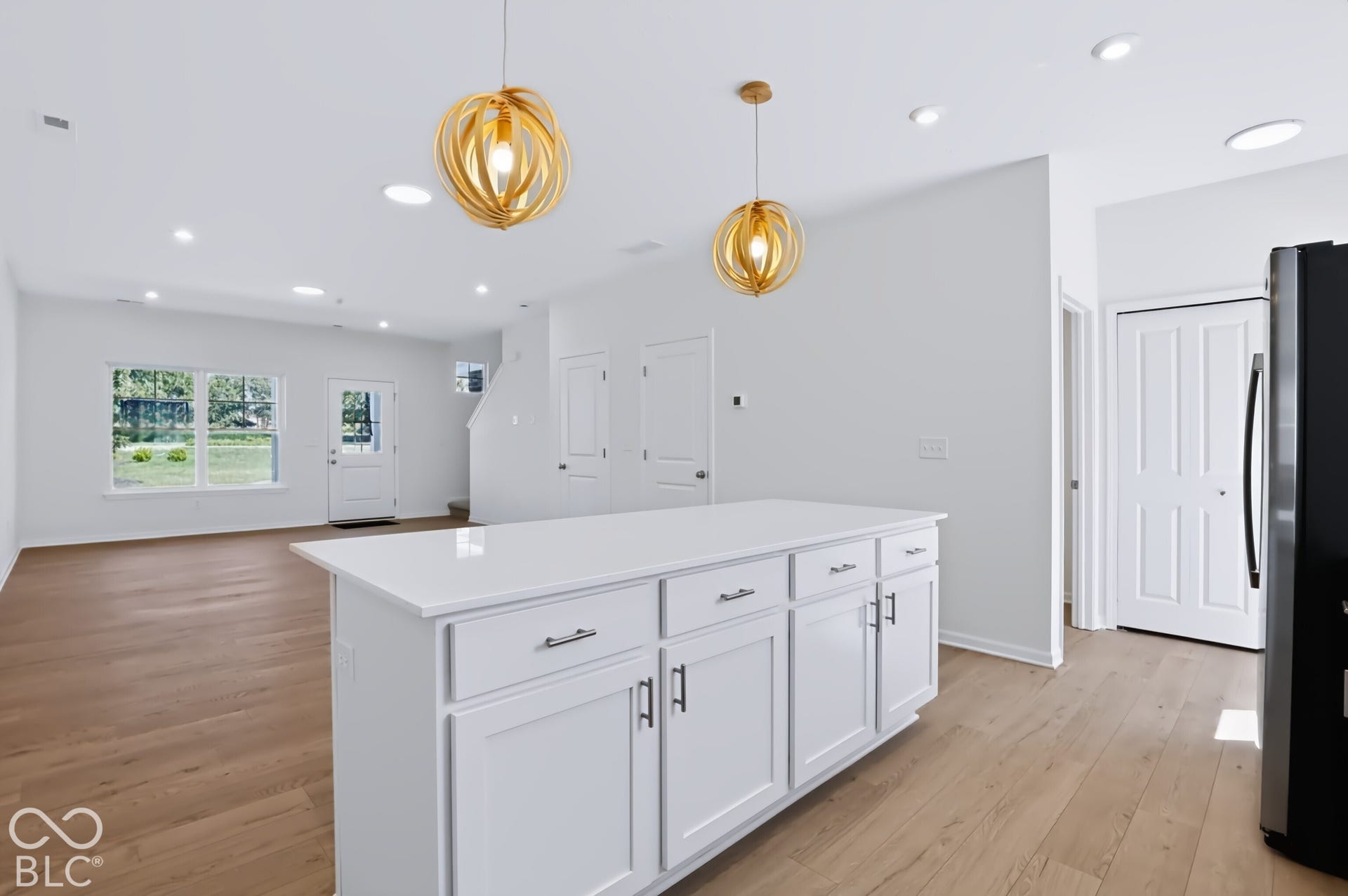 Kitchen island with white cabinetry, white countertop, and contemporary pendant lighting