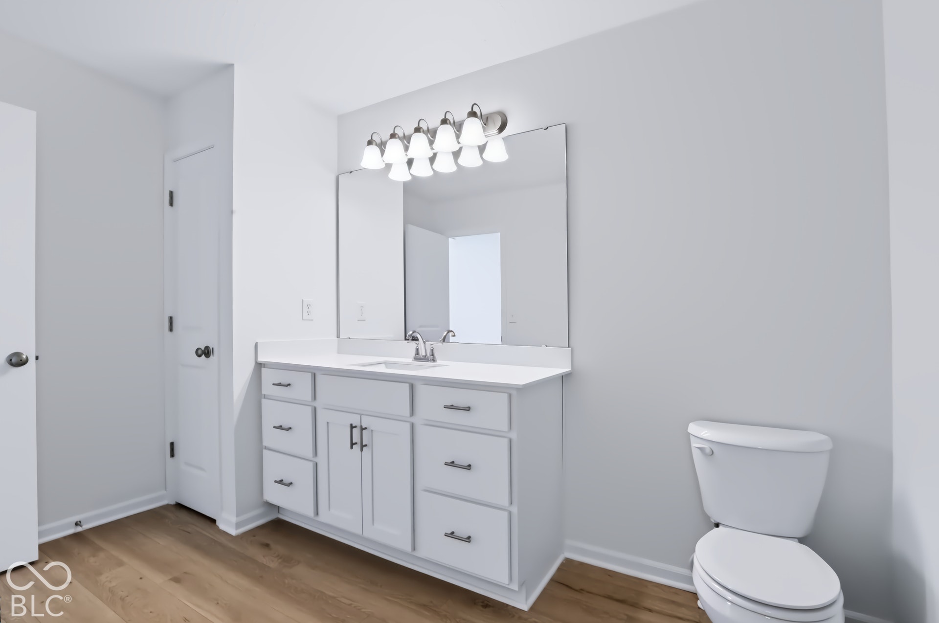 White vanity with a single basin, ample storage, and a polished chrome faucet