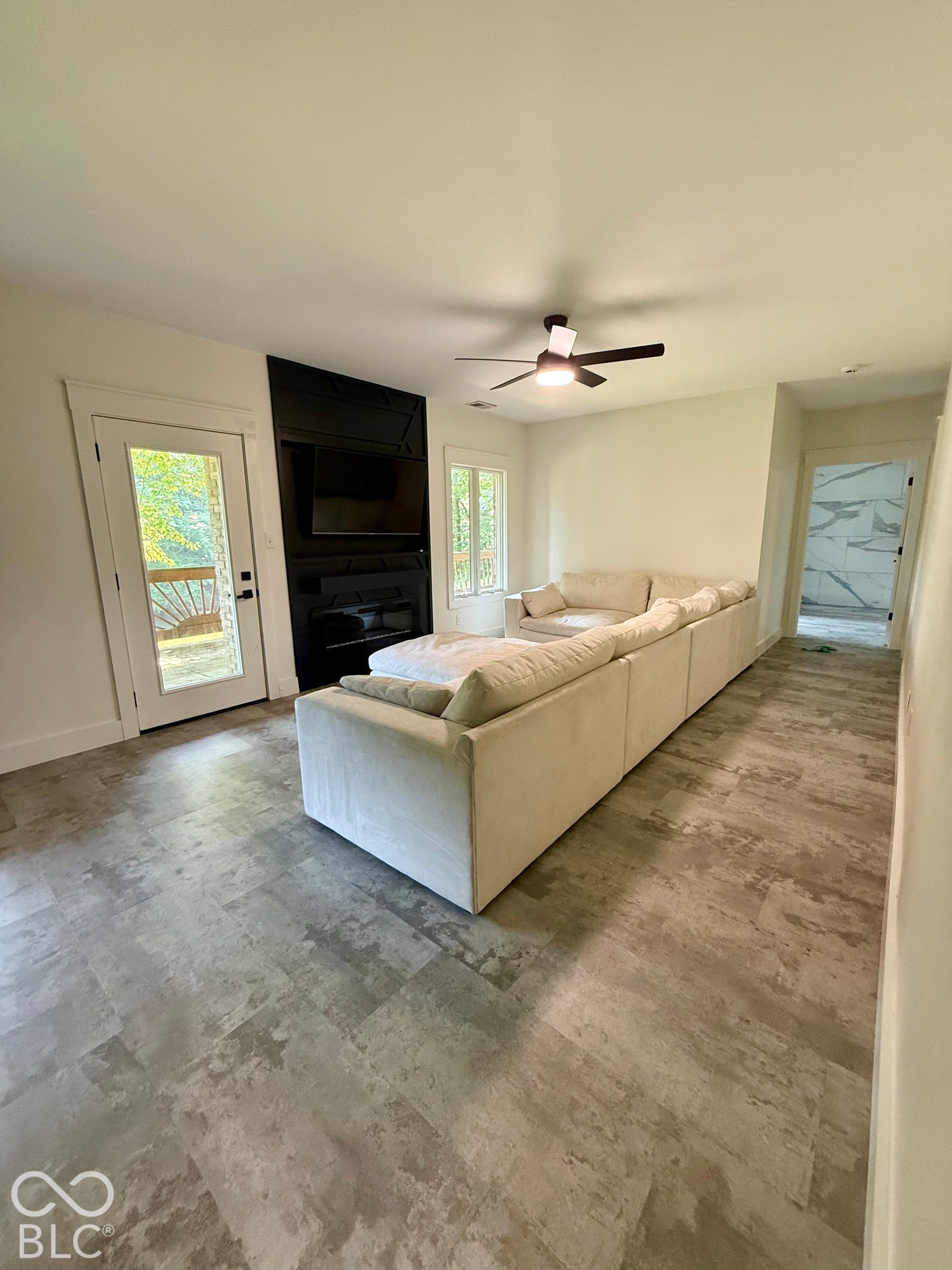 Spacious living room in basement, featuring custom electric fireplace