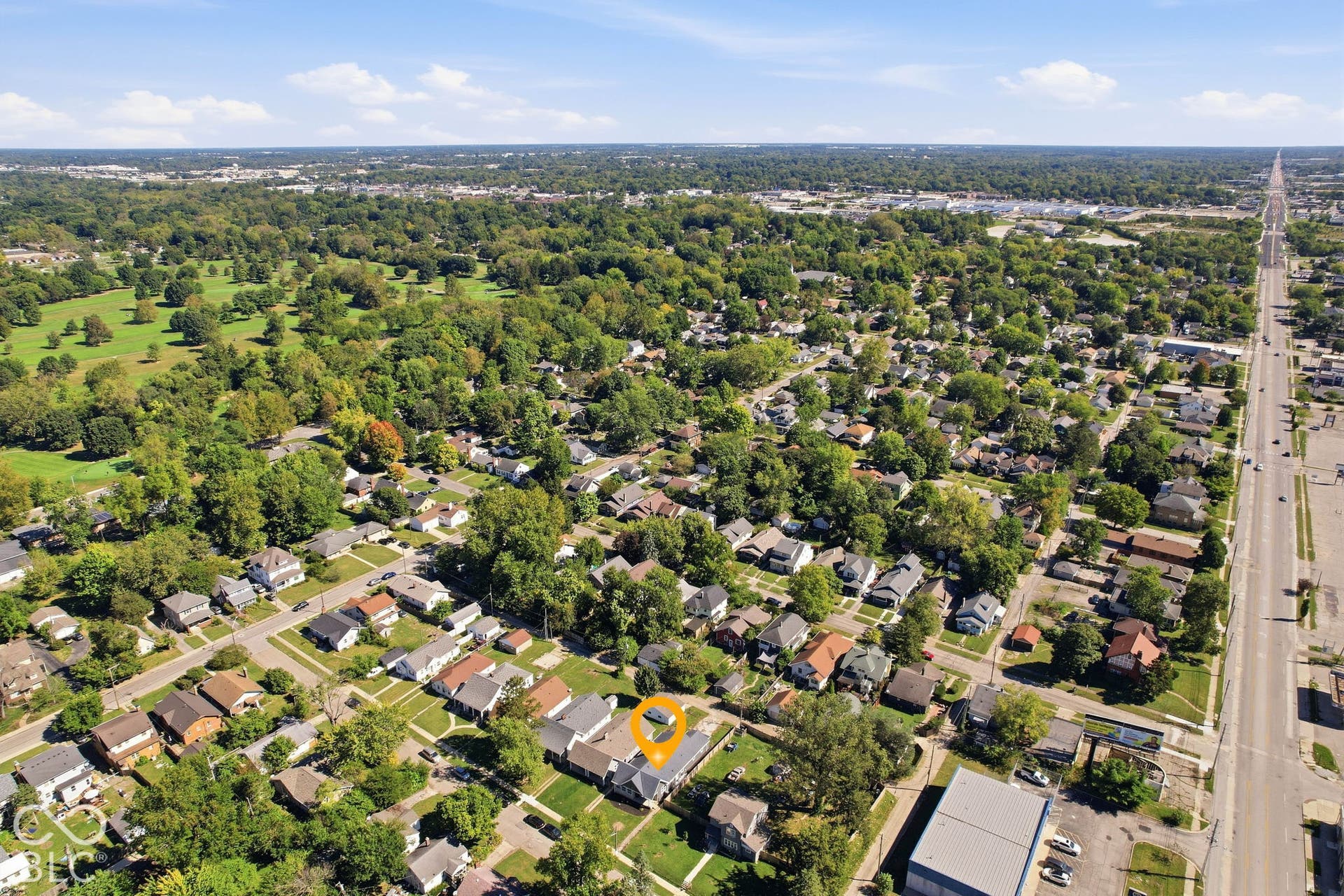 Residential neighborhood setting with mature trees and a nearby green space