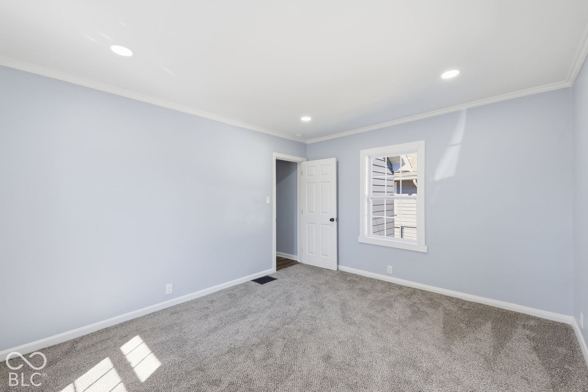 Light blue walls with white trim, gray carpeted flooring, and recessed ceiling lighting
