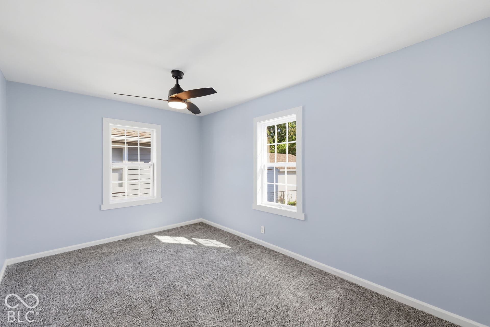 Plush gray carpeting, white trim, and a contemporary ceiling fan with integrated lighting