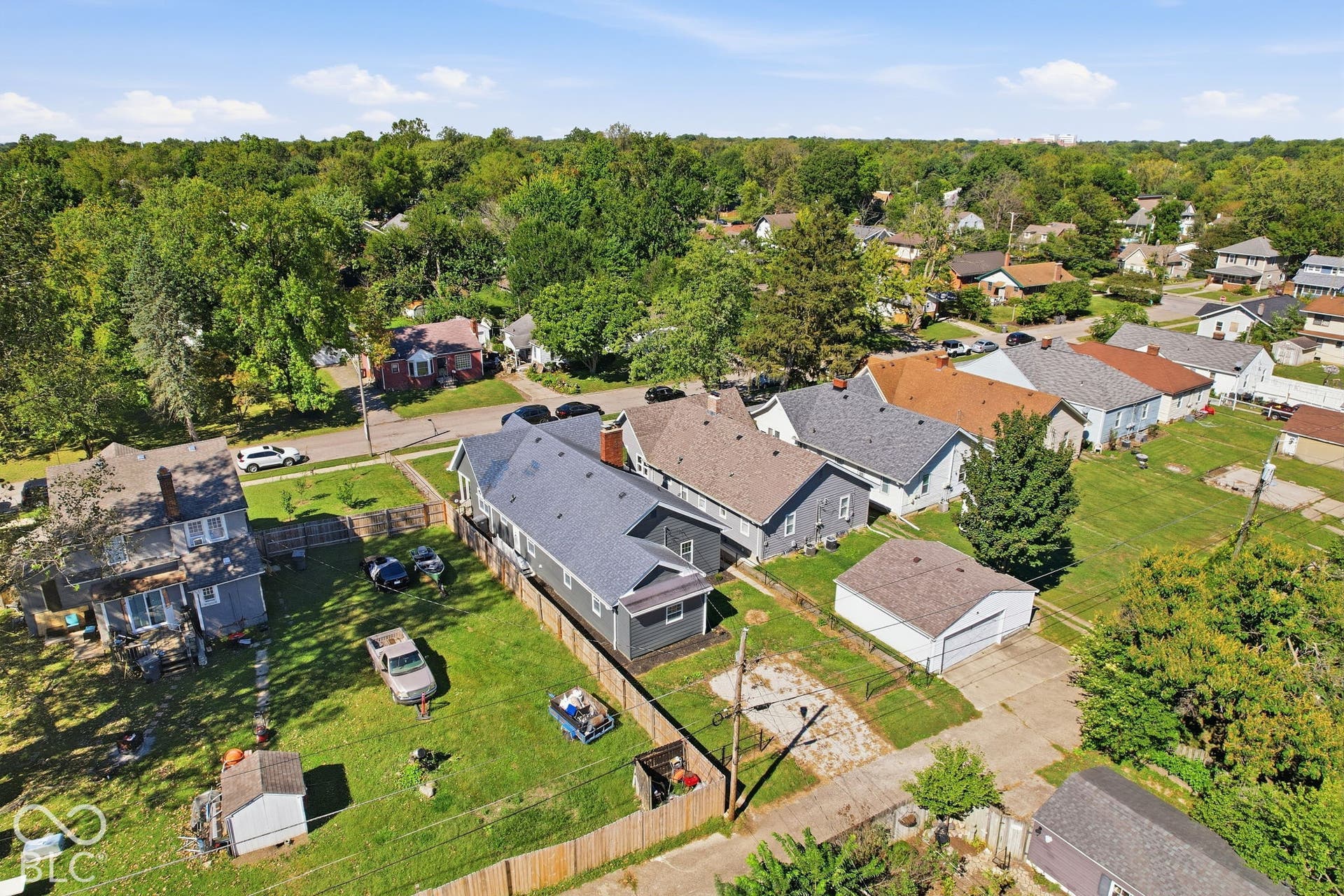 Neighborhood setting featuring a mix of residential properties, paved streets, and mature trees