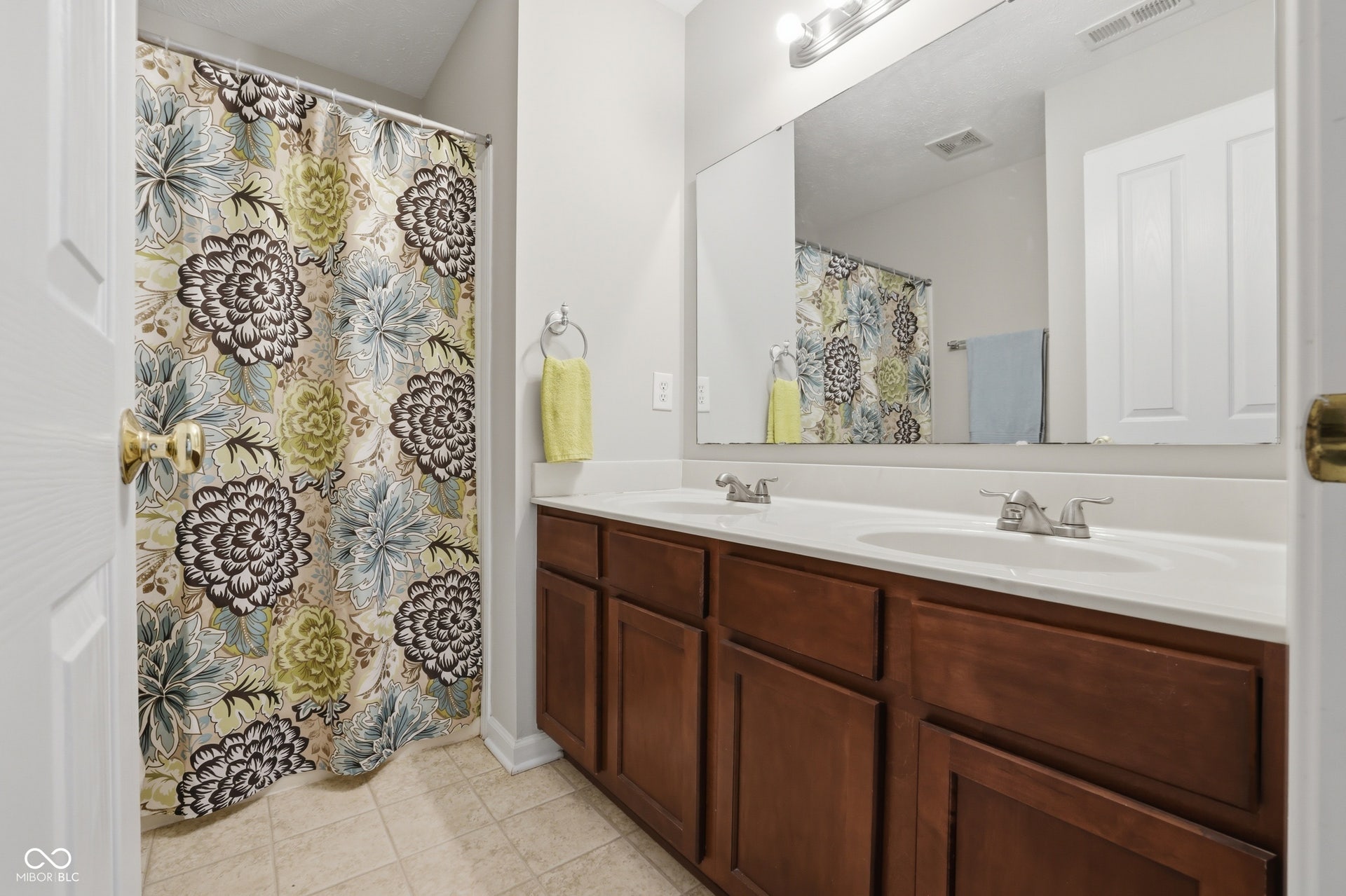 Dual vanity featuring white countertops, two integrated sinks, and brushed nickel faucets for the upstairs bedrooms. Linen closet for easy access and ample cabinet storage.