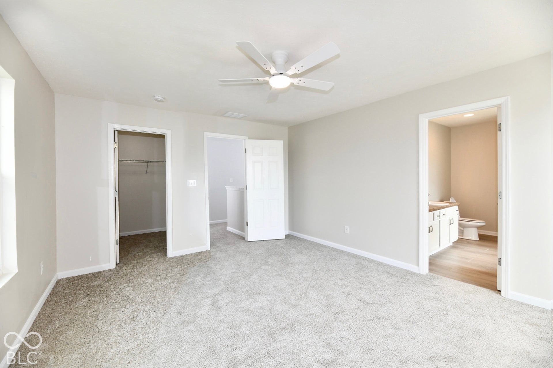 Soft gray carpeting, white painted walls, and a ceiling fan with integrated lighting