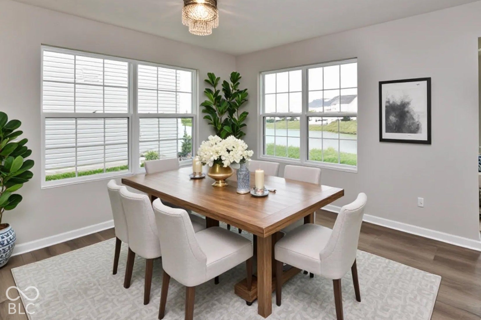 Virtually Altered - Wood-finish flooring, multiple windows, contemporary chandelier, light gray wall tones, and white trim