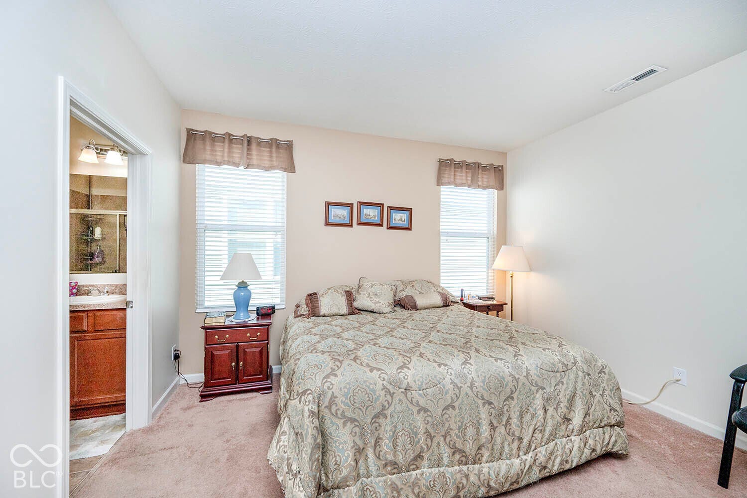 The Primary Bedroom features neutral wall paint, carpeted flooring, and two windows with horizontal blinds. Seller will consider a carpet allowance for this room with a reasonable offer.