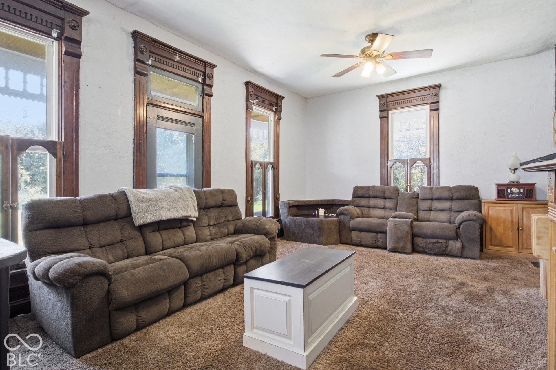 Ornate wood trim detailing, ceiling fan, and carpeted flooring