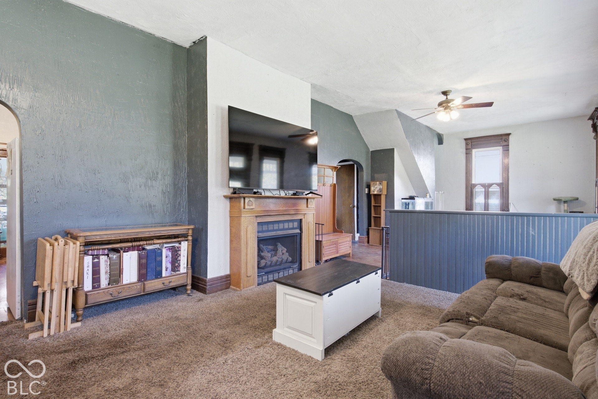 Living area with a built-in fireplace featuring a wood surround and decorative tile