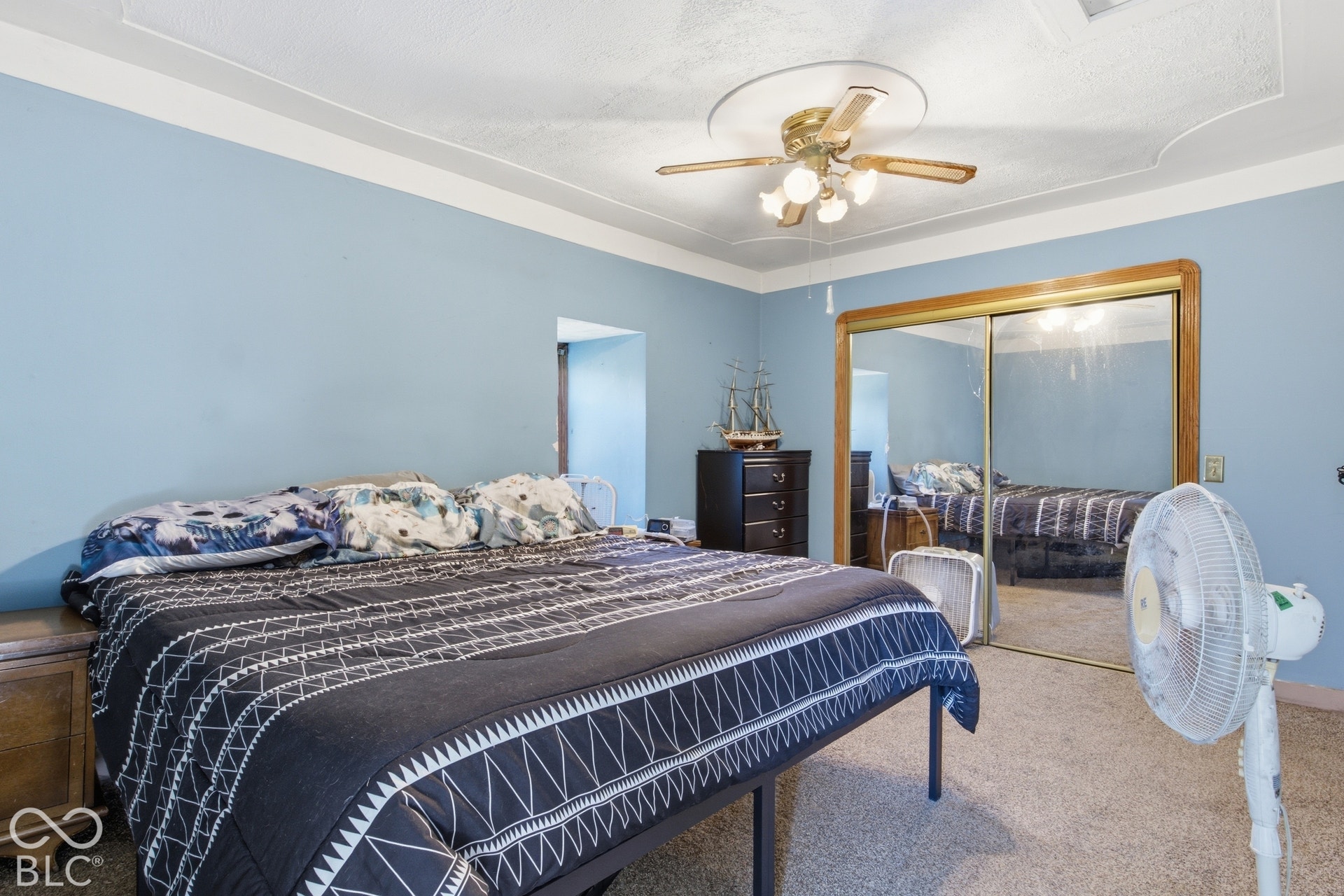 Bedroom with carpet flooring, crown molding, and a ceiling fan with light fixture