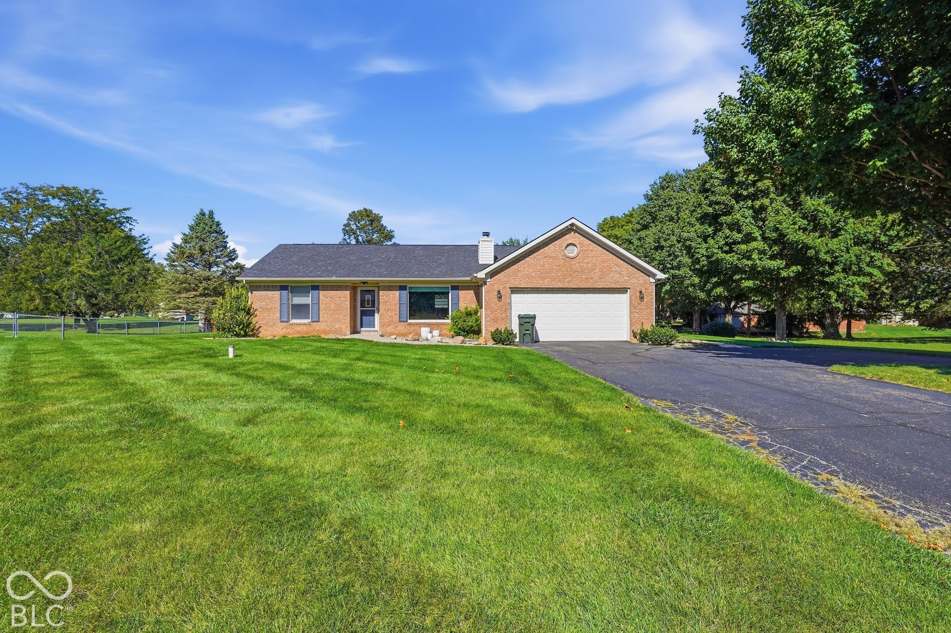 Brick exterior featuring a two-car garage and a dark shingle roof