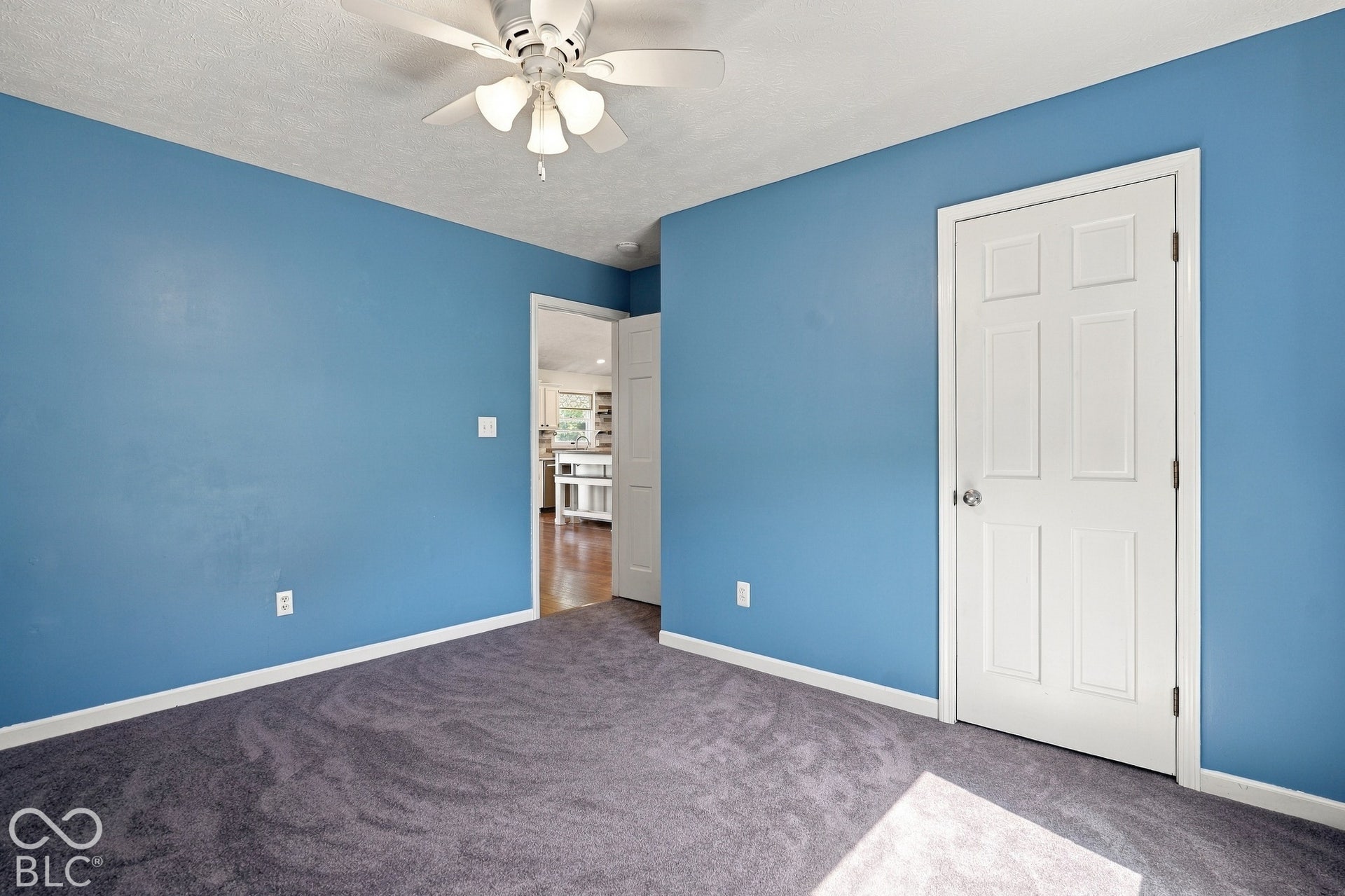 Wall-to-wall carpeting and a ceiling fan with light fixture