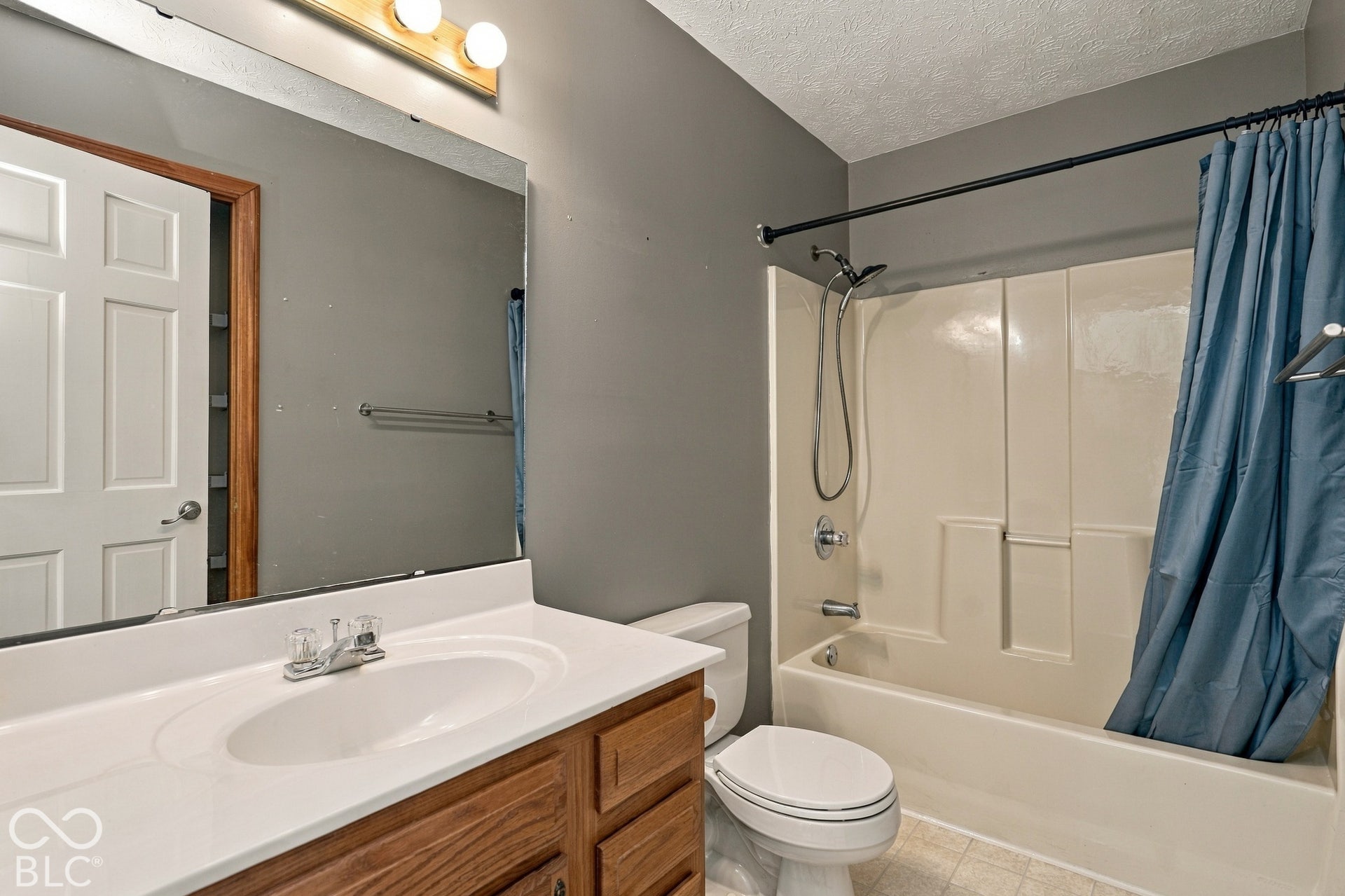 Wood-finish vanity with an integrated sink and chrome faucet