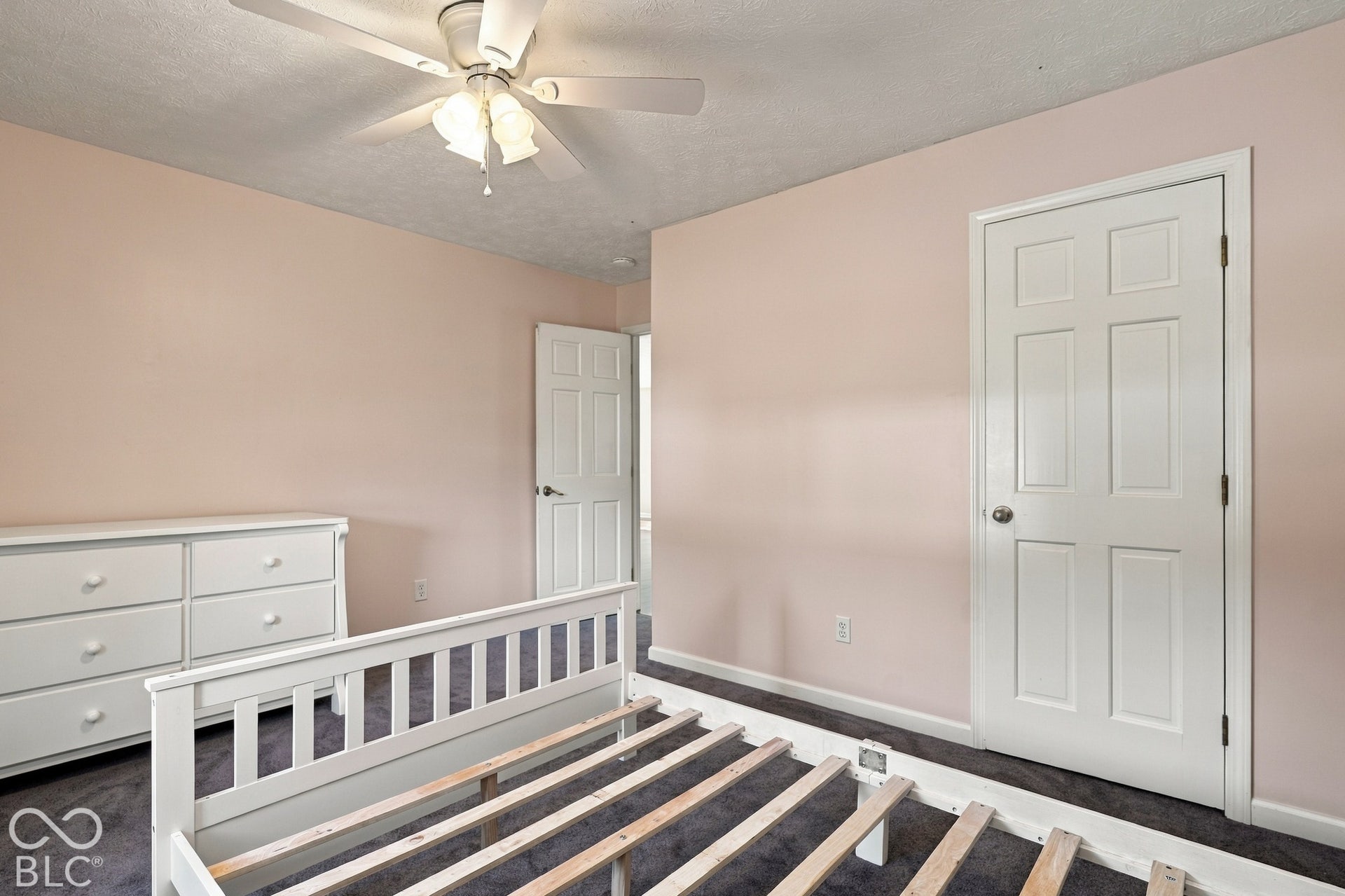 Wall-to-wall carpeting with light-toned walls, a ceiling fan with light fixture, and white paneled doors