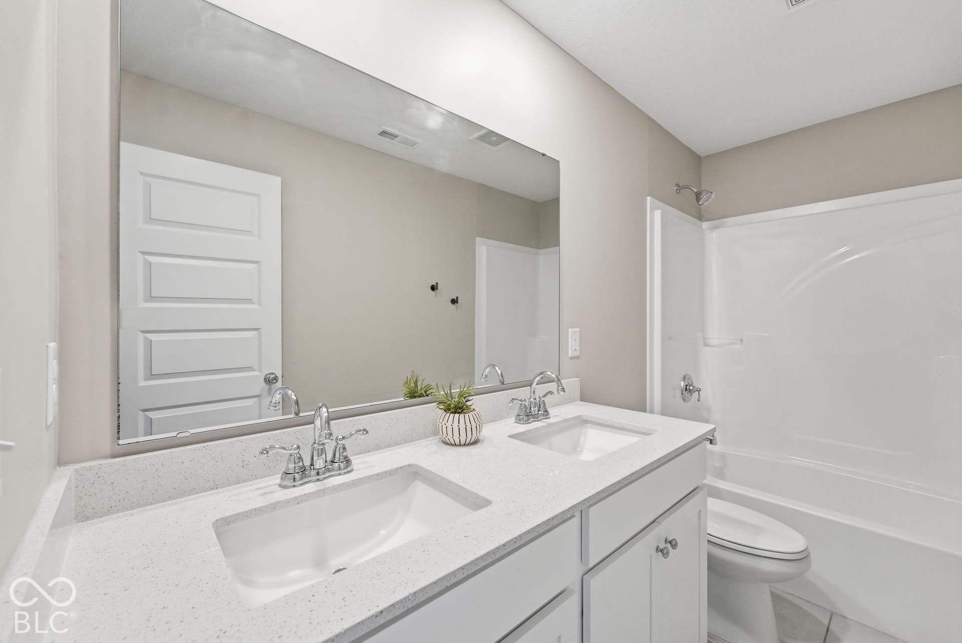 Full bathroom in upstairs hallway with double sinks and tub/shower combo.