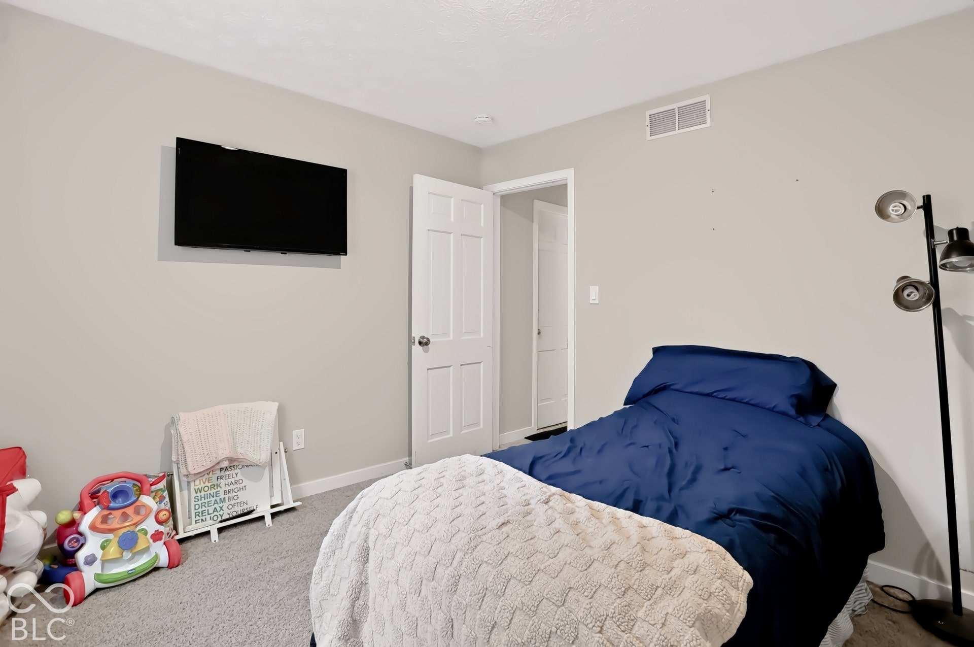 Neutral-toned walls complement the textured carpet flooring