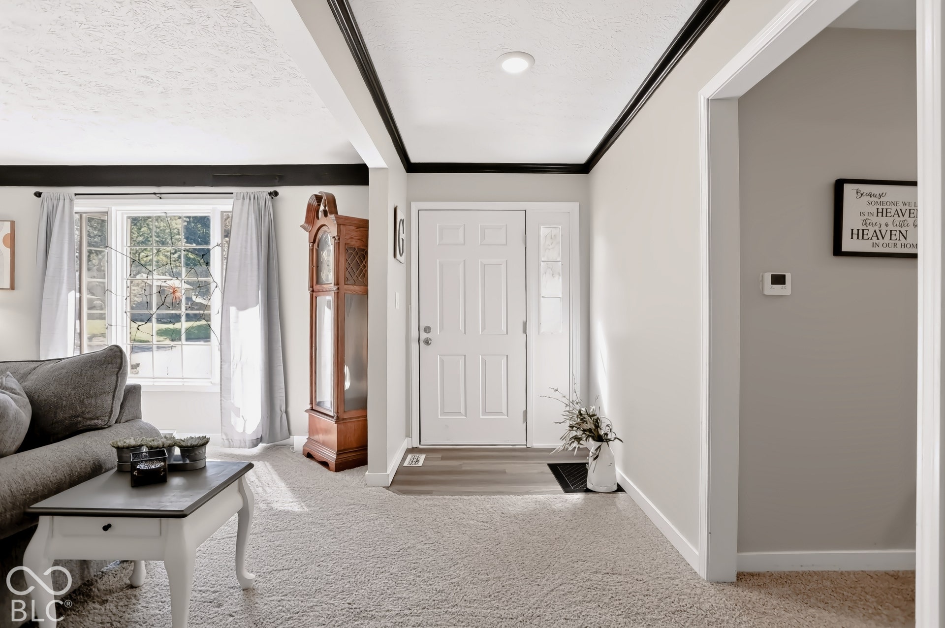 Entryway with a paneled door, sidelights, and overhead transom window