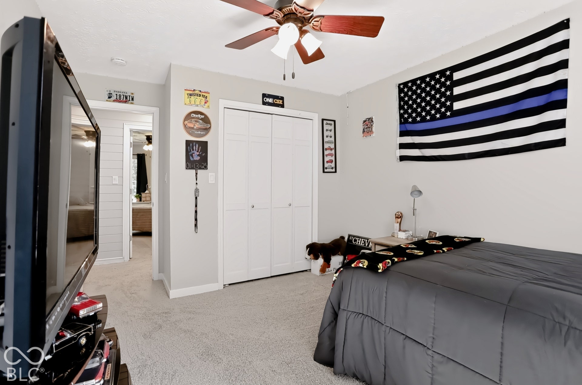 Carpeted bedroom with a ceiling fan